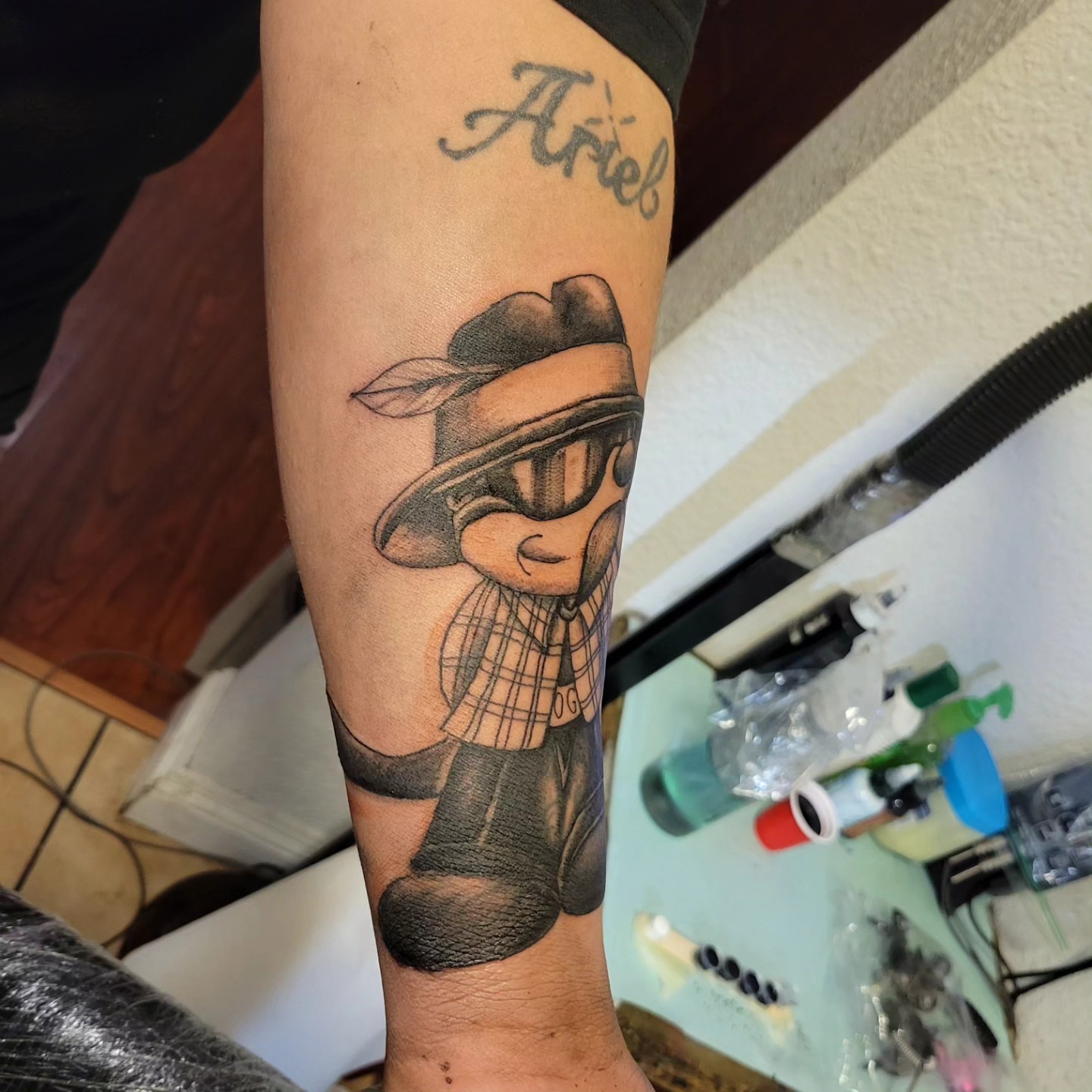Cartoon character black and grey tattoo on the forearm by Markus Hicks