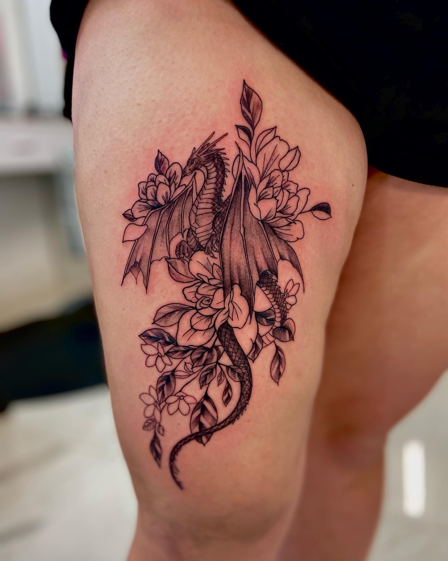 Dragon and flowers realism tattoo on the thigh by Aldocasales@tatto