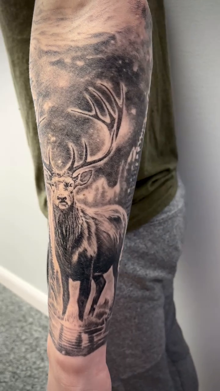 Elk in a forest landscape realism tattoo by Charlie