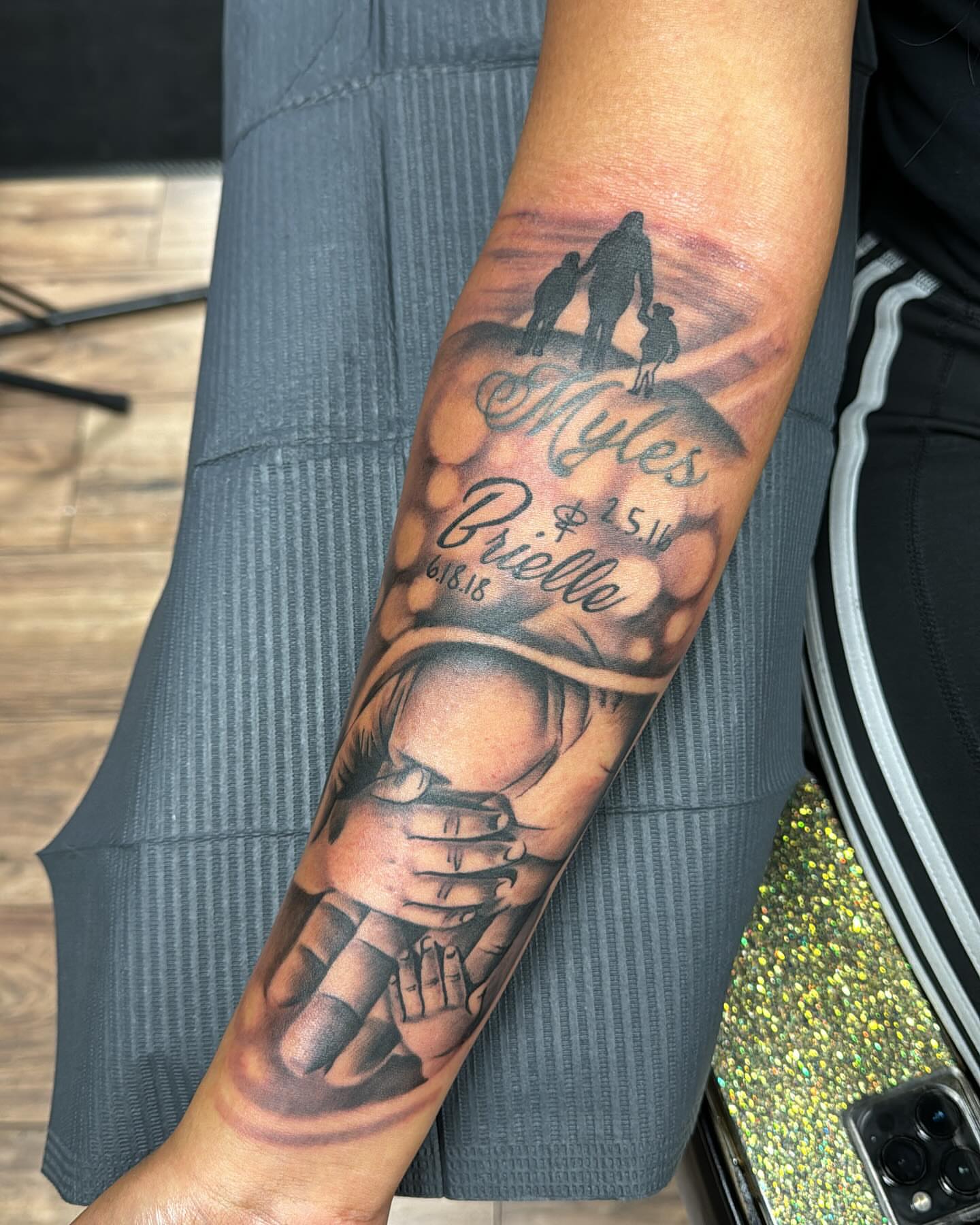 Family scene realism tattoo on the forearm by Cedric Fleming