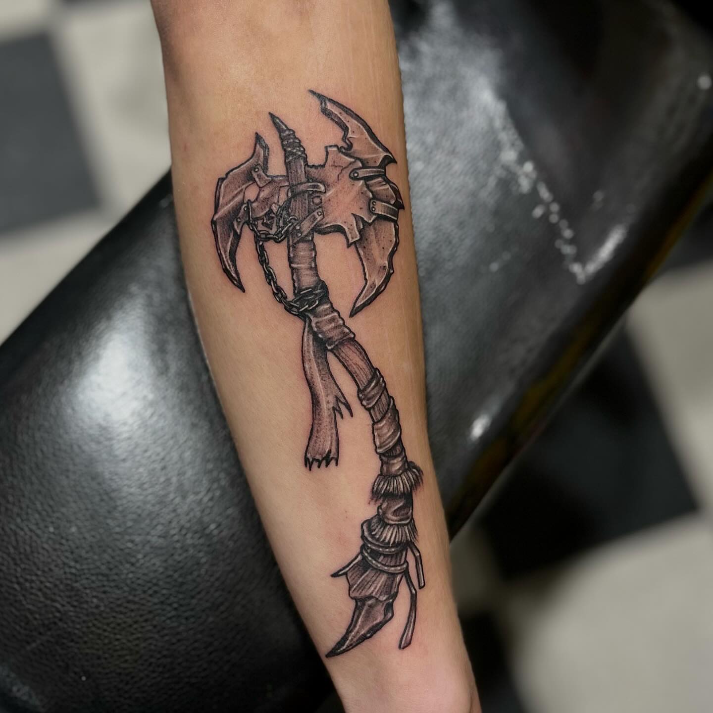 Battle axe black and grey tattoo on the forearm by Morgan Jones