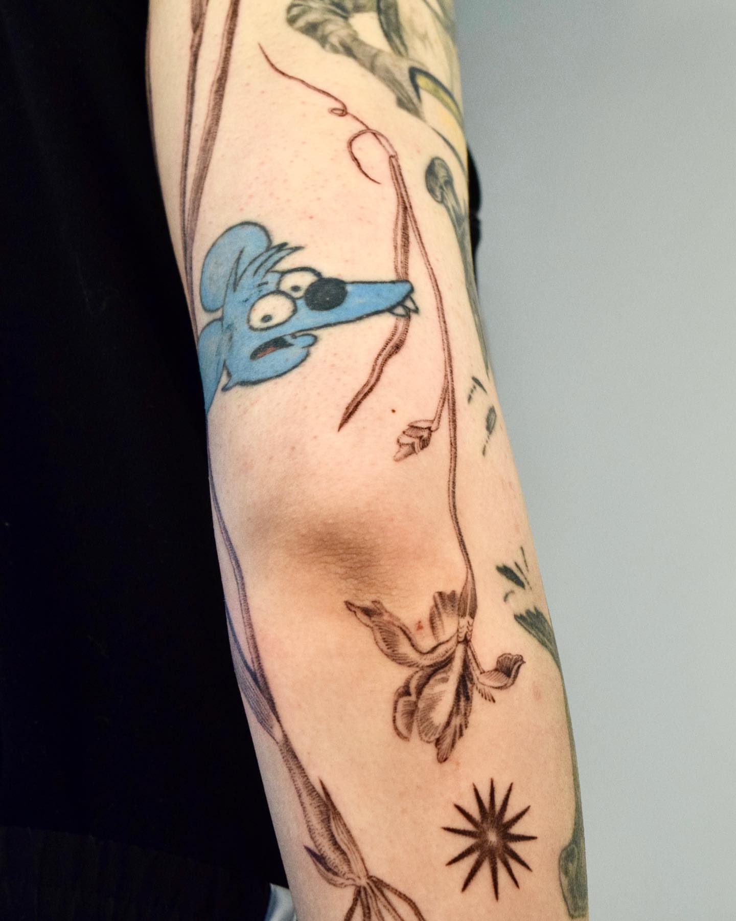 Mouse hanging from vine American traditional tattoo on the forearm by Stella Oh