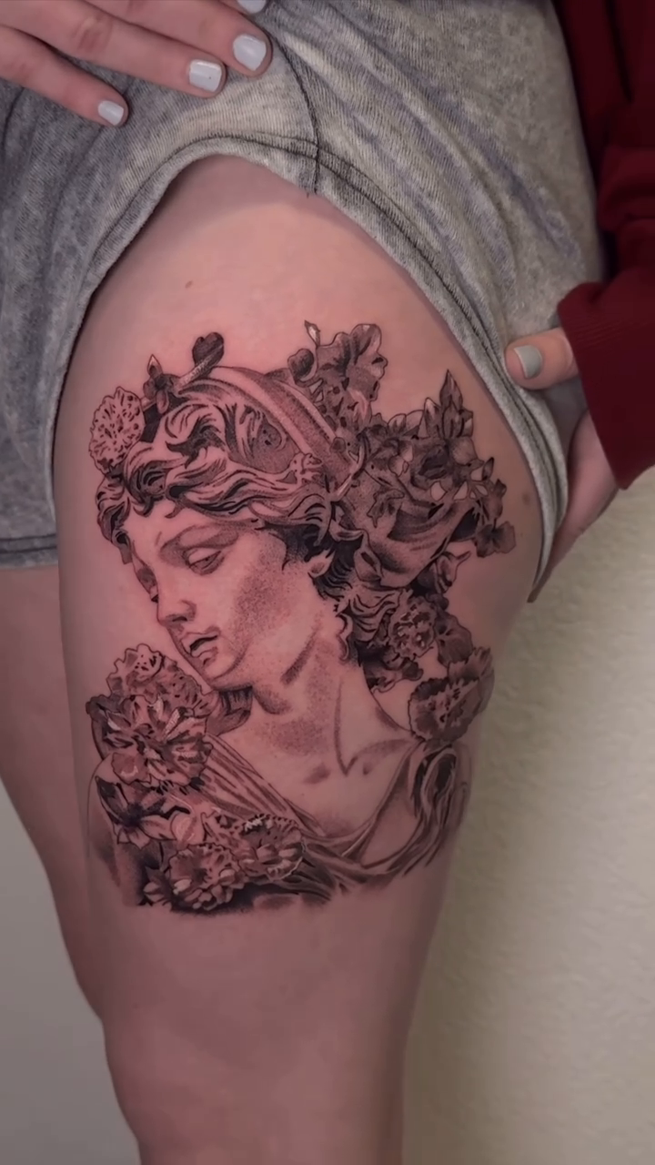 Bust of a woman with flowers realism tattoo by Chip