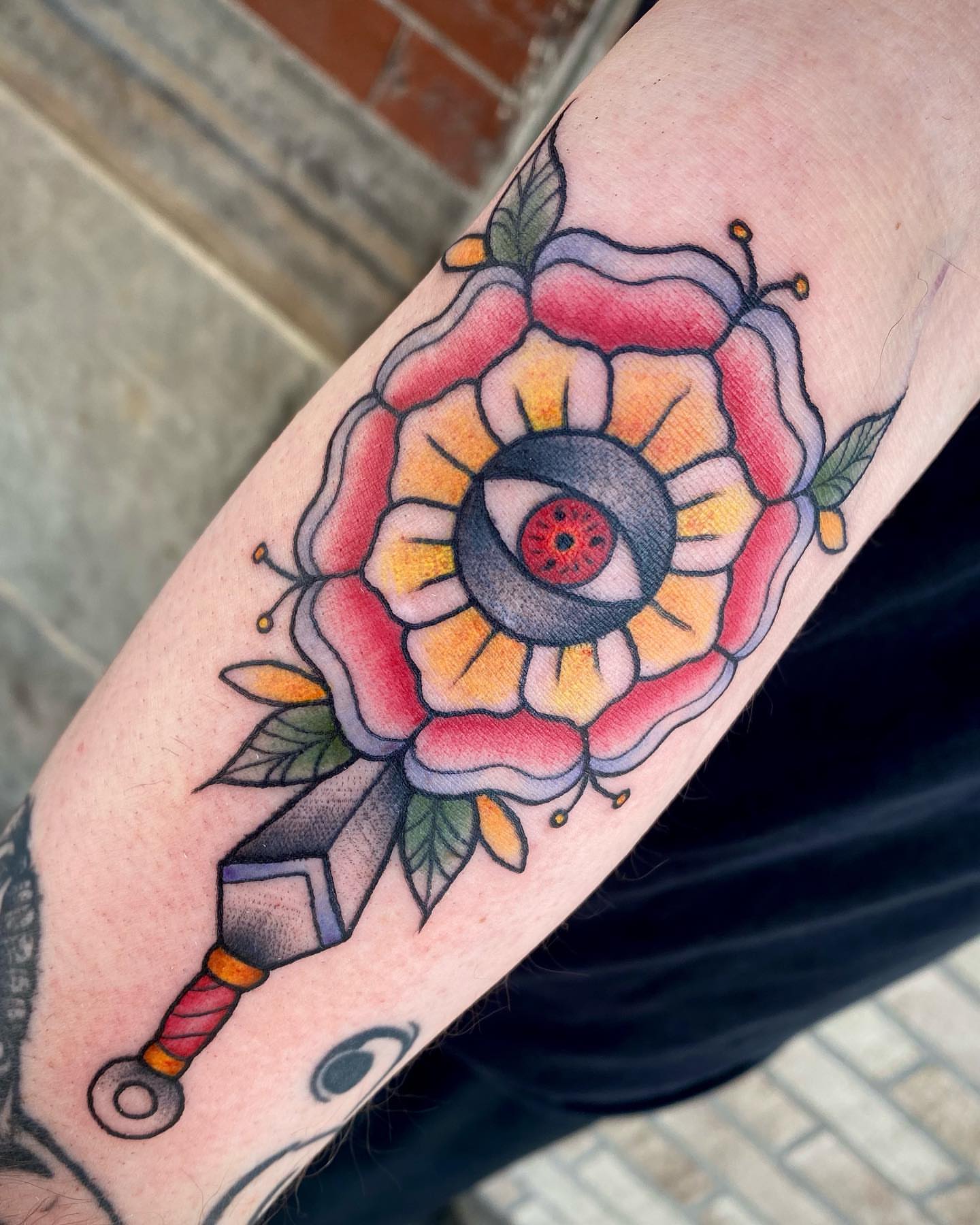 Flower with eye American traditional tattoo on the forearm by Savanna Starr Mortensen