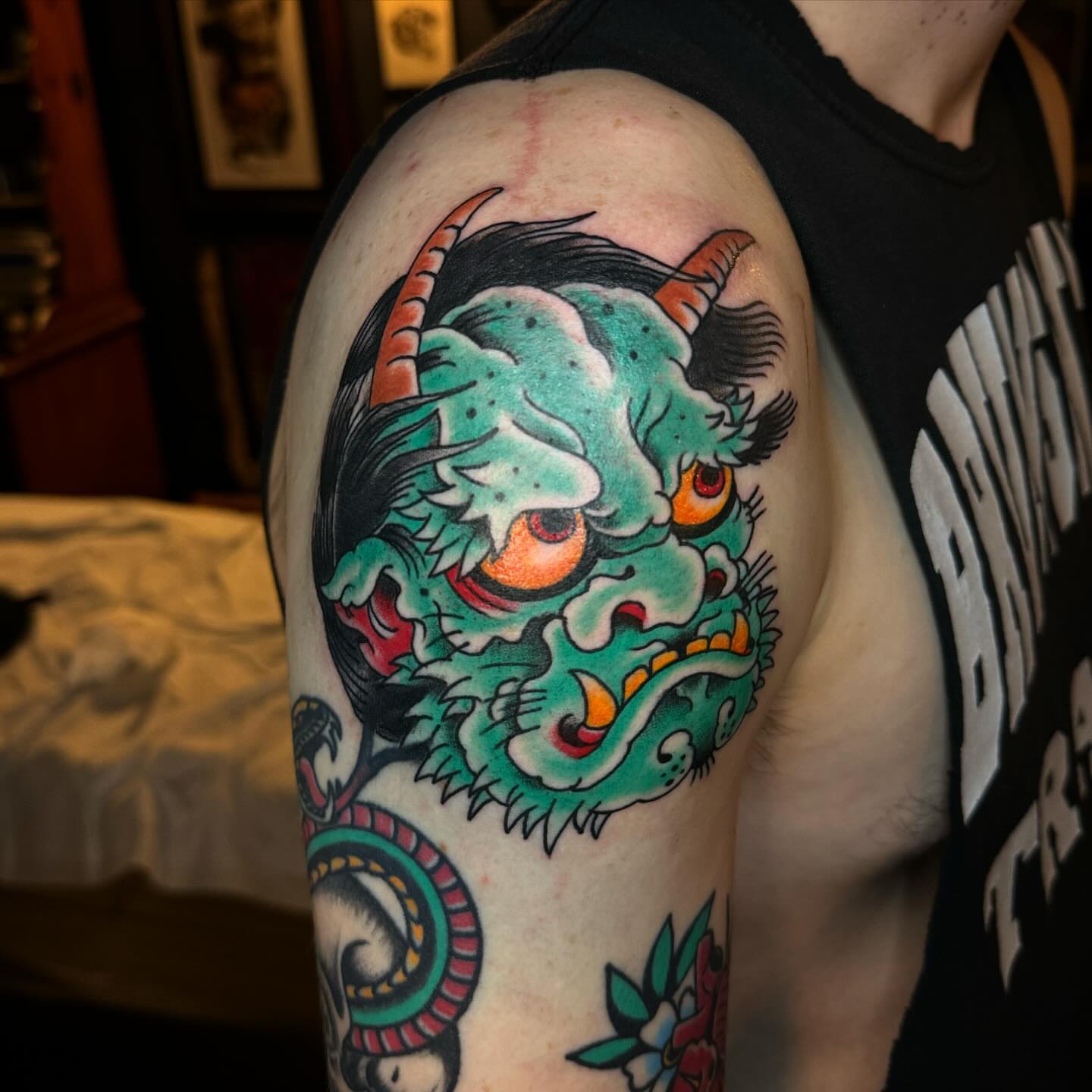 Demon head American traditional tattoo on the shoulder by Ethan Bennett
