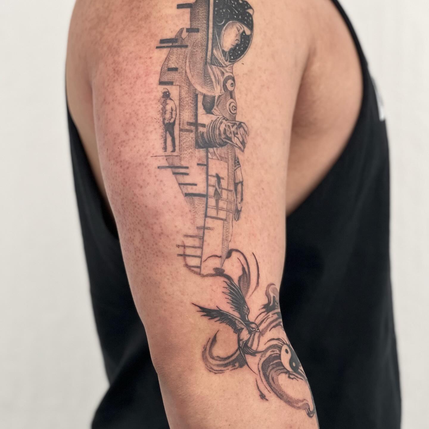 Astronaut and bird geometric tattoo on the upper arm by Riki