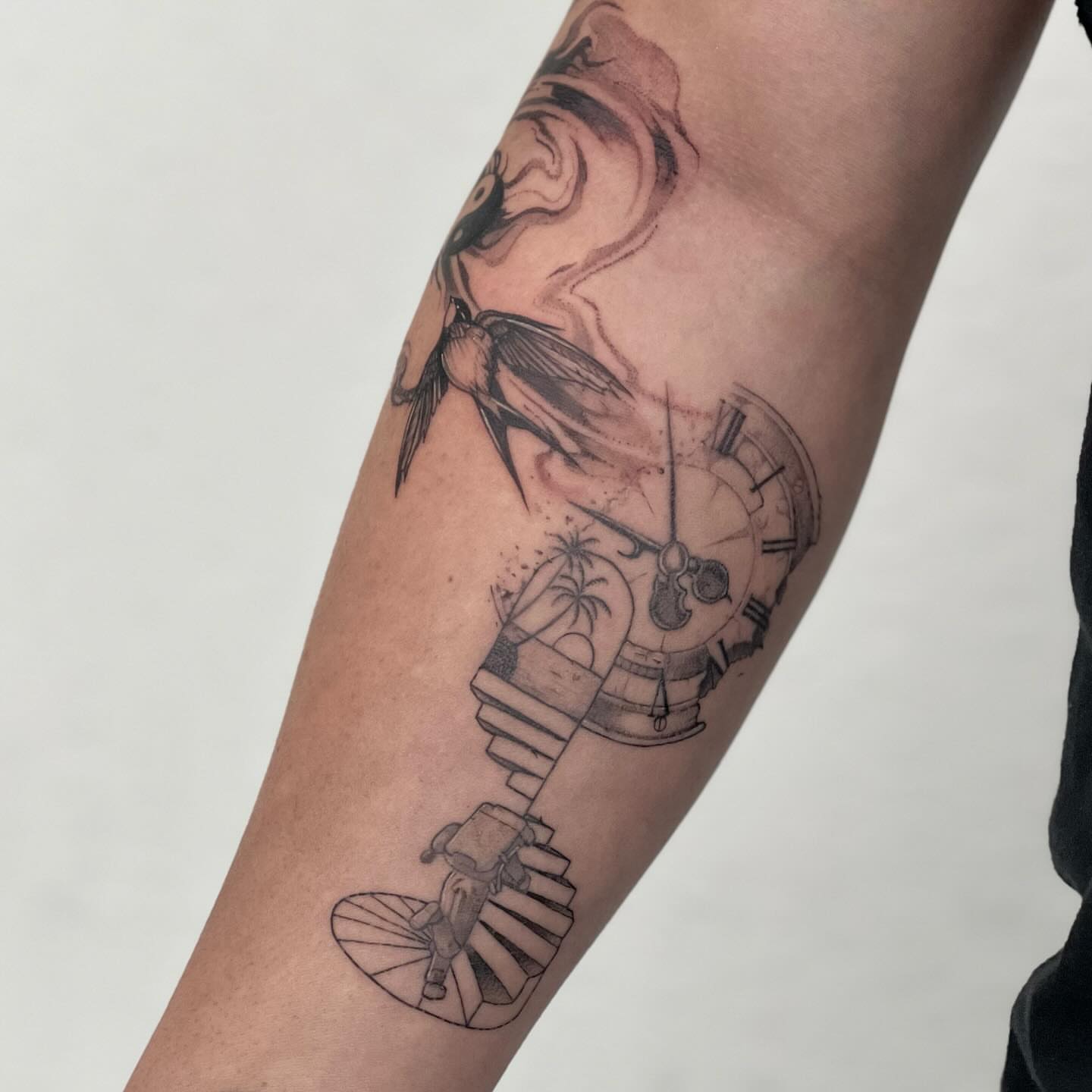 Swallow and clock black and grey tattoo on the forearm by Riki
