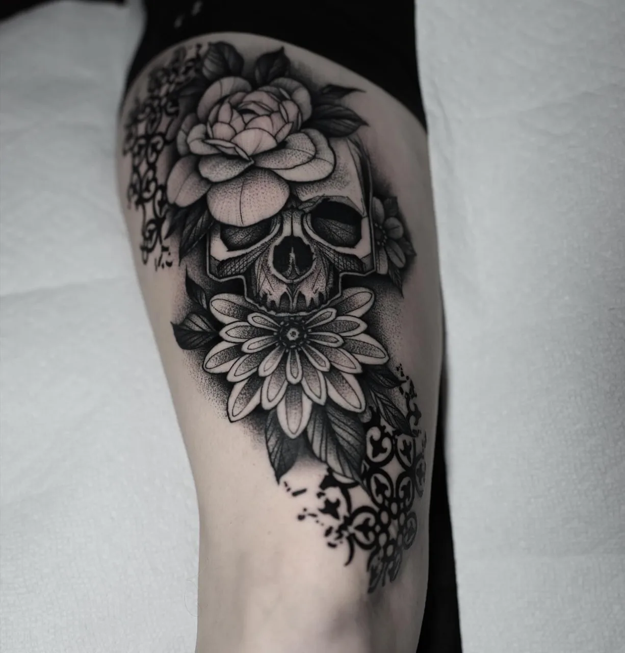 Skull and flowers dotwork tattoo on the forearm by David Mushaney