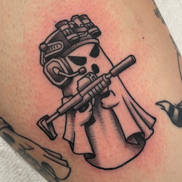 Skull with rifle black and grey tattoo on the thigh by David Gottschalk