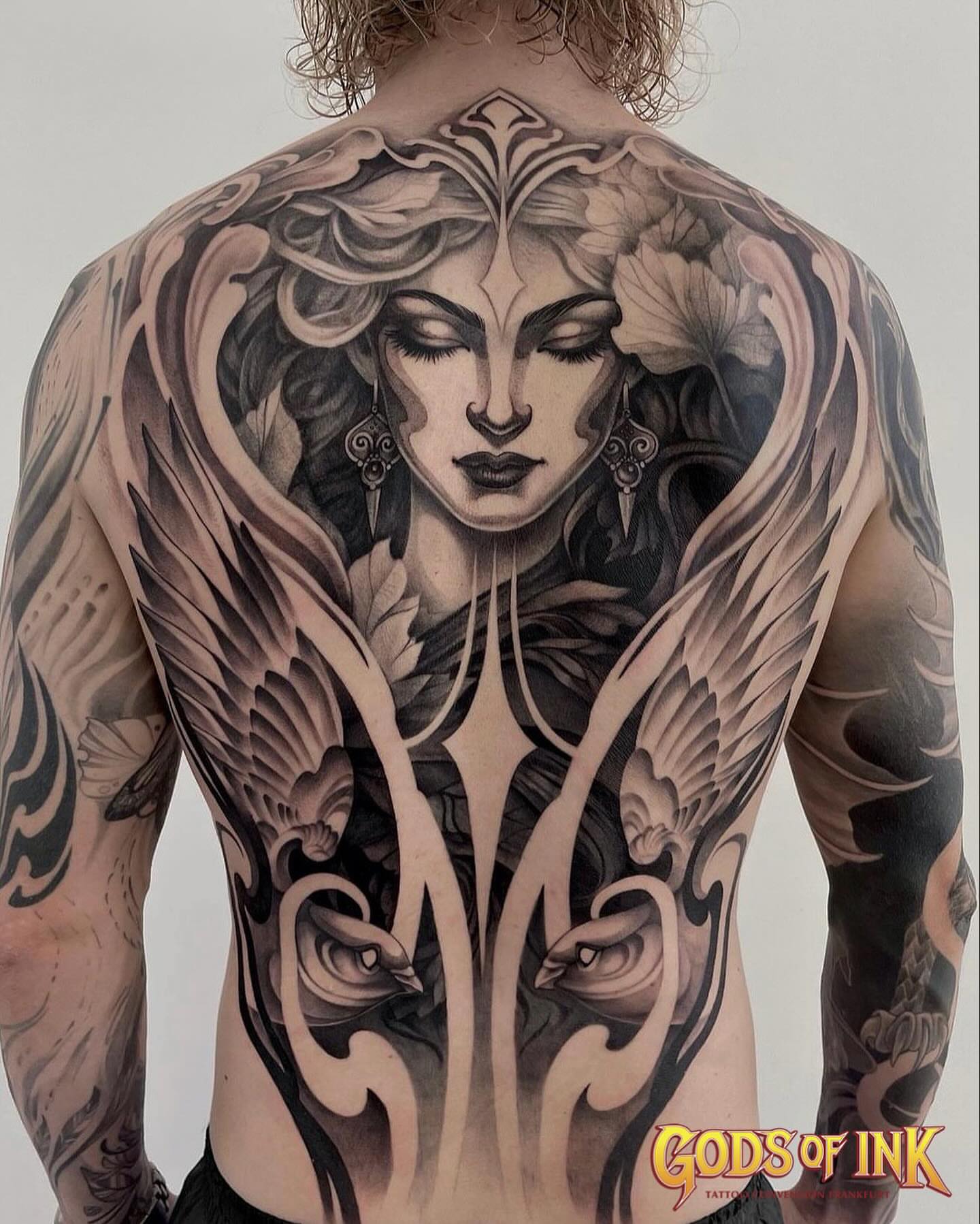 Woman with wings illustrative tattoo on the back by Michelle Carlton