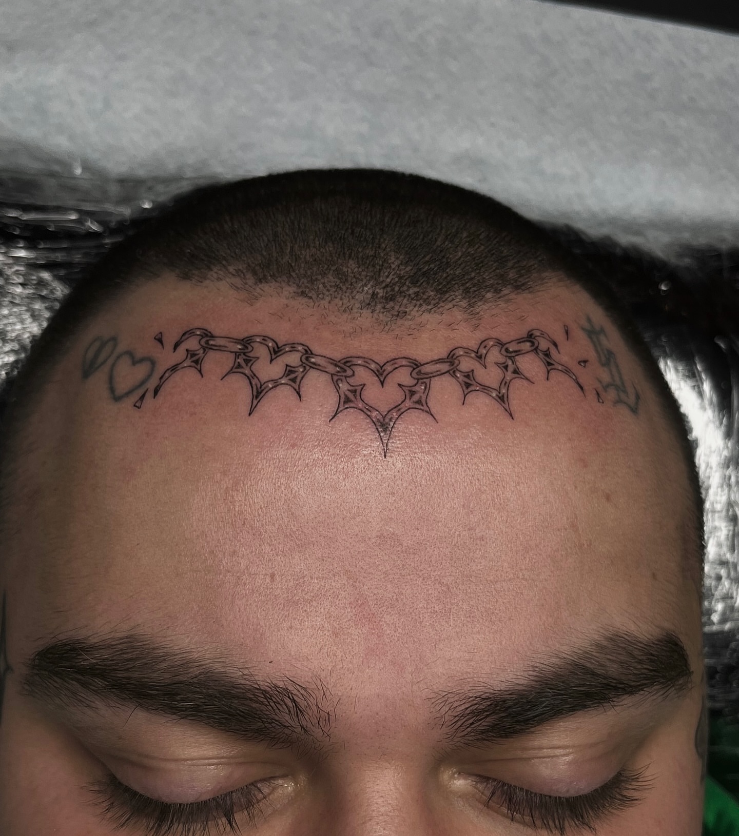 Chain of hearts black and grey tattoo on the head by Taylor Newton