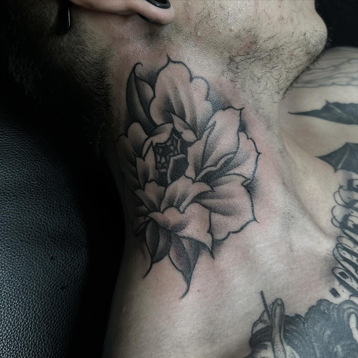 Flower black and grey tattoo on the neck by Tattoosxjoseph