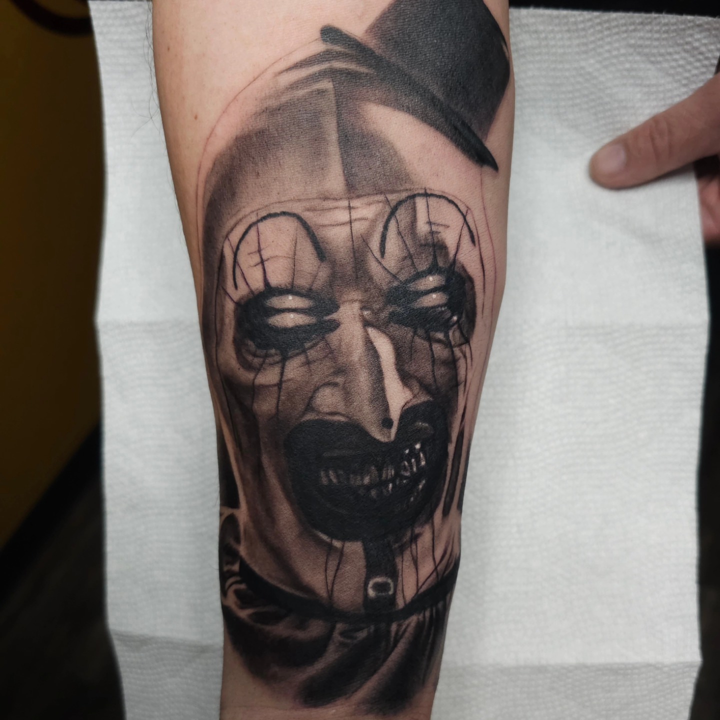 Clown mask realism tattoo on the forearm by Dan Redding