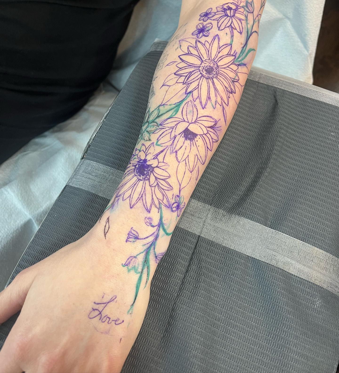Daisies new school tattoo on the forearm by Tattoo Yulia Kononenko