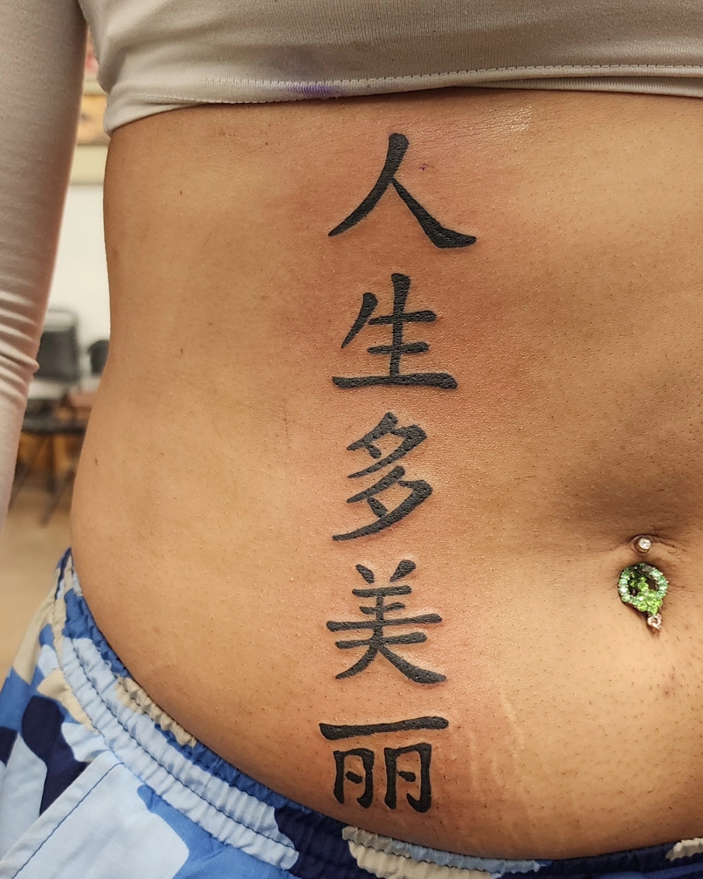 Life is beautiful lettering script tattoo on the torso by @thedevilspaintbrush_