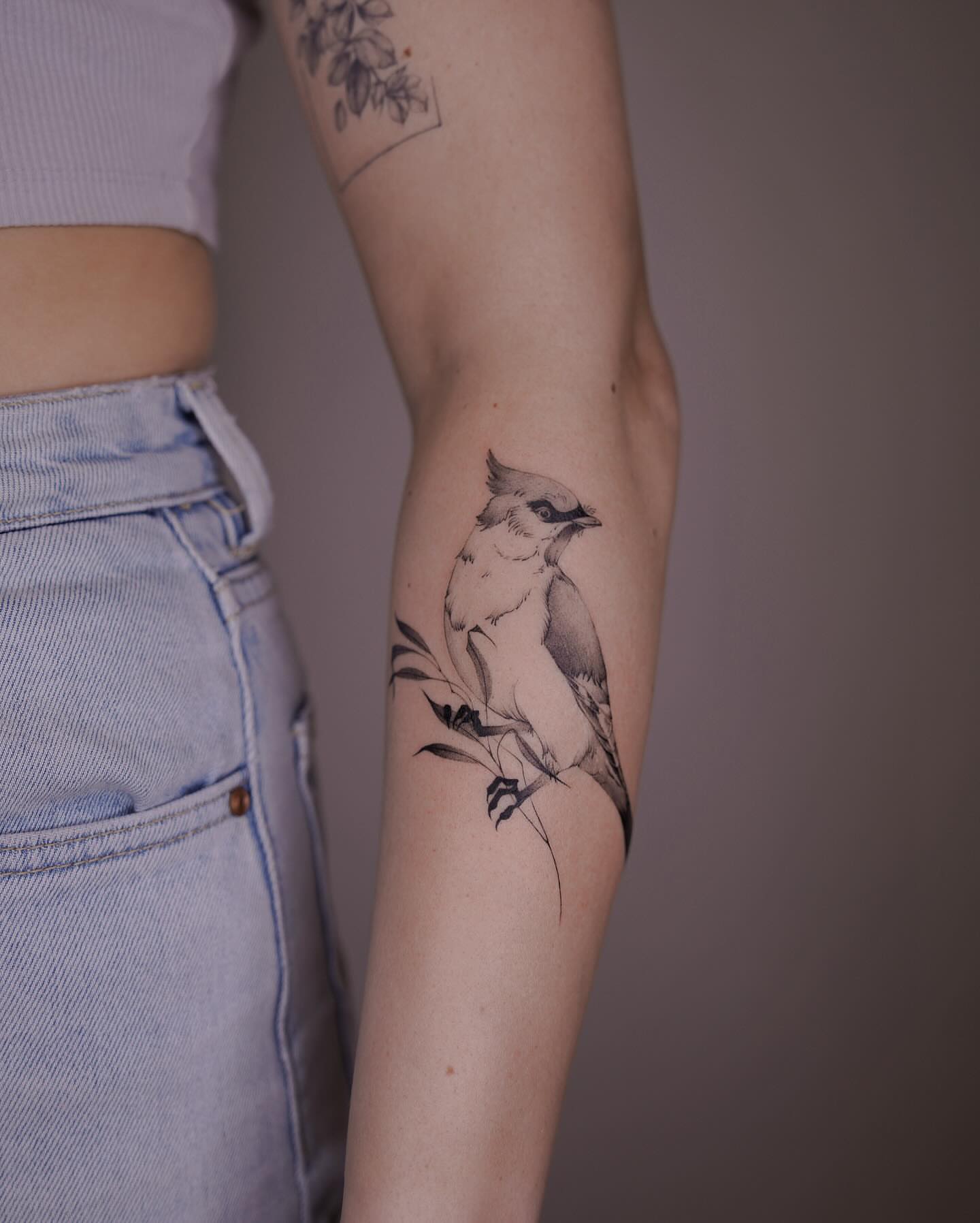 Bird black and grey tattoo on the forearm by Tattoo Artist