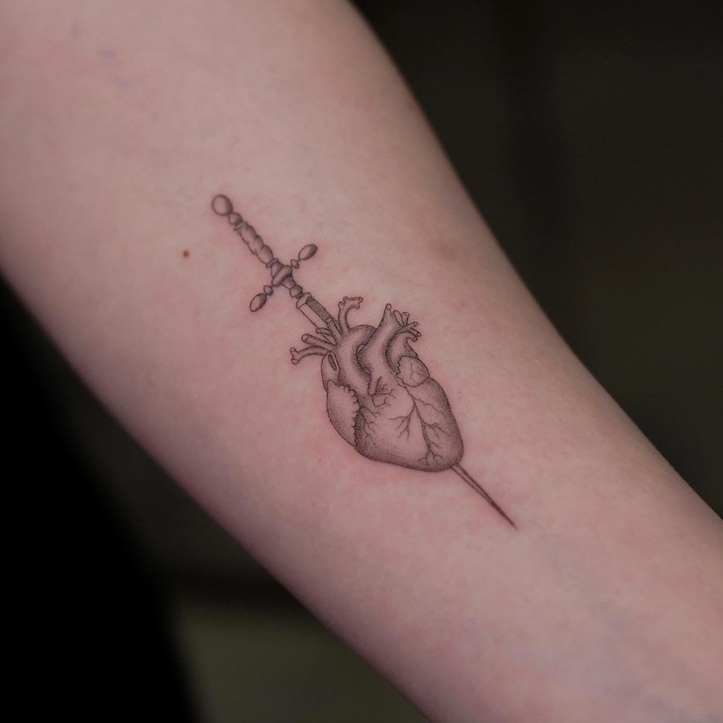 Heart and sword realism tattoo on the forearm by eddie chavez