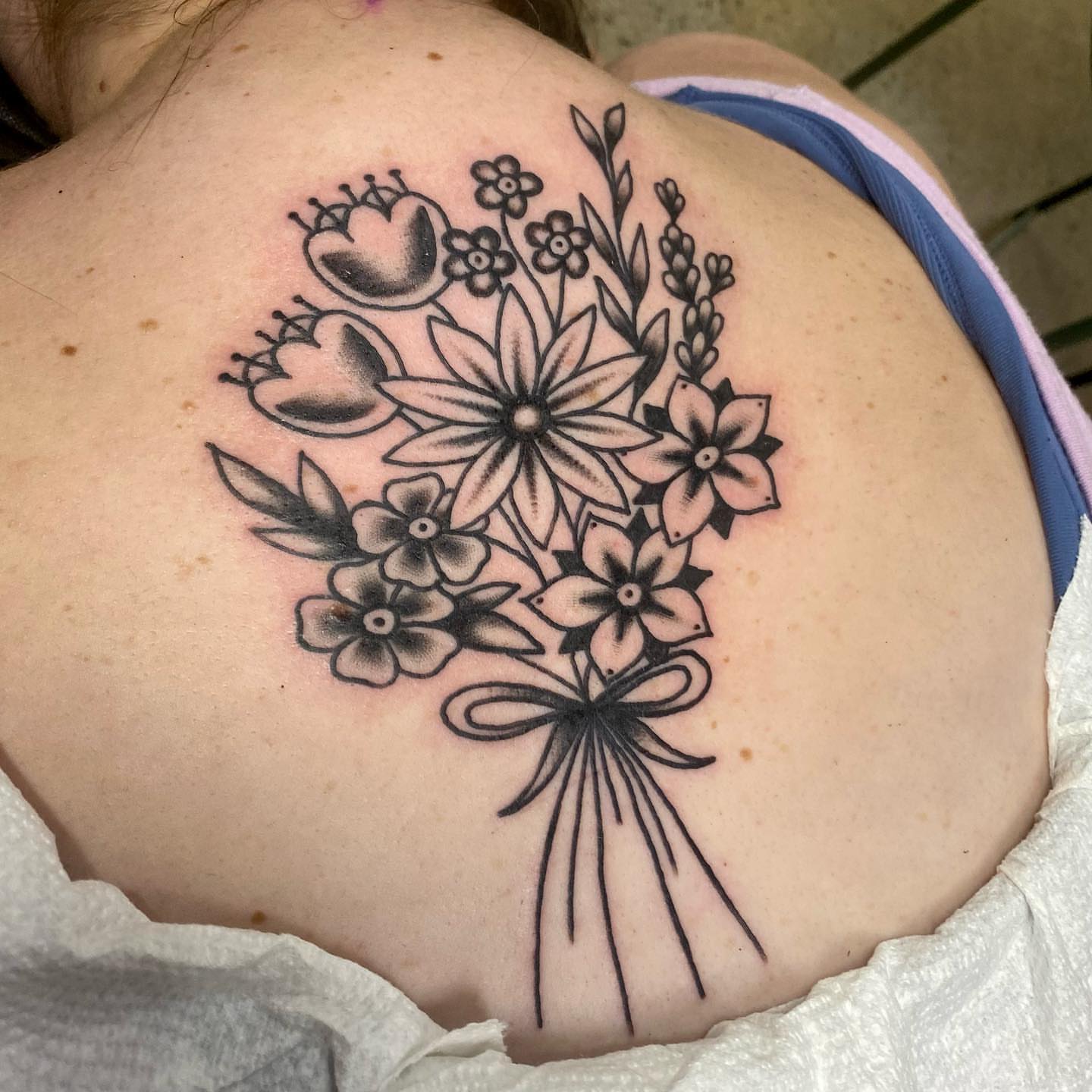 Flower bouquet black and grey tattoo on the back by Shana