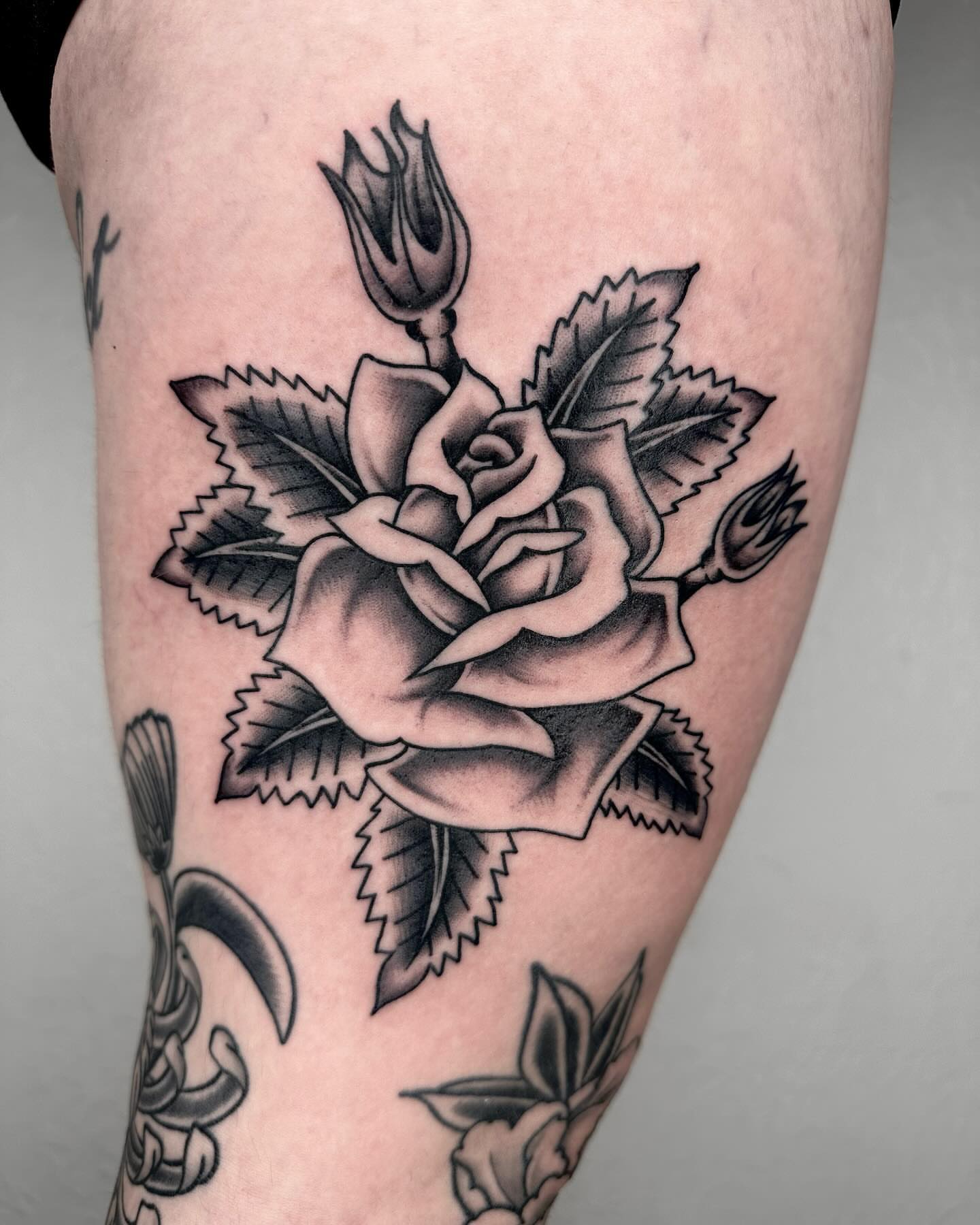 Rose black and grey tattoo on the thigh by Elijah Edwards