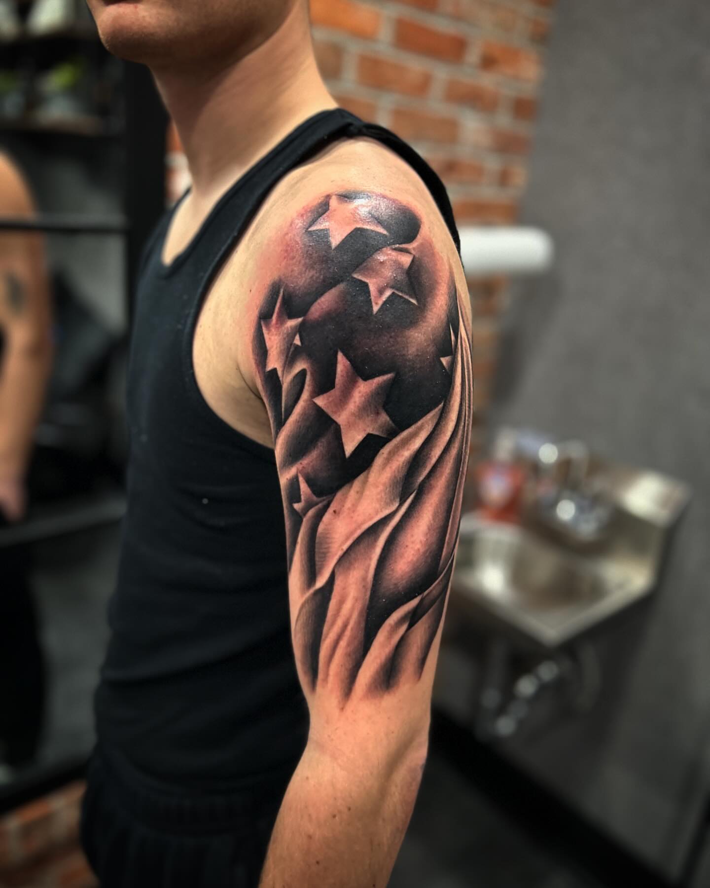 Stars and stripes American traditional tattoo on the upper arm by Brian Keith