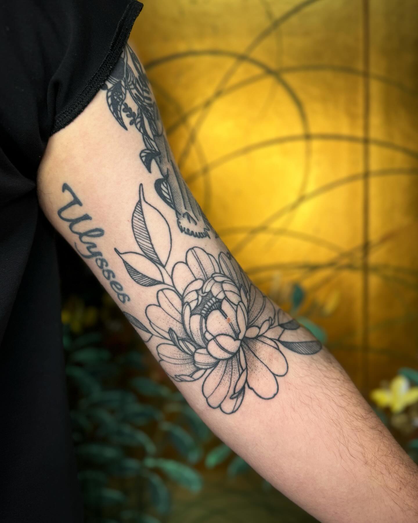 Chrysanthemum and leaves black and grey tattoo on the forearm by Mazie