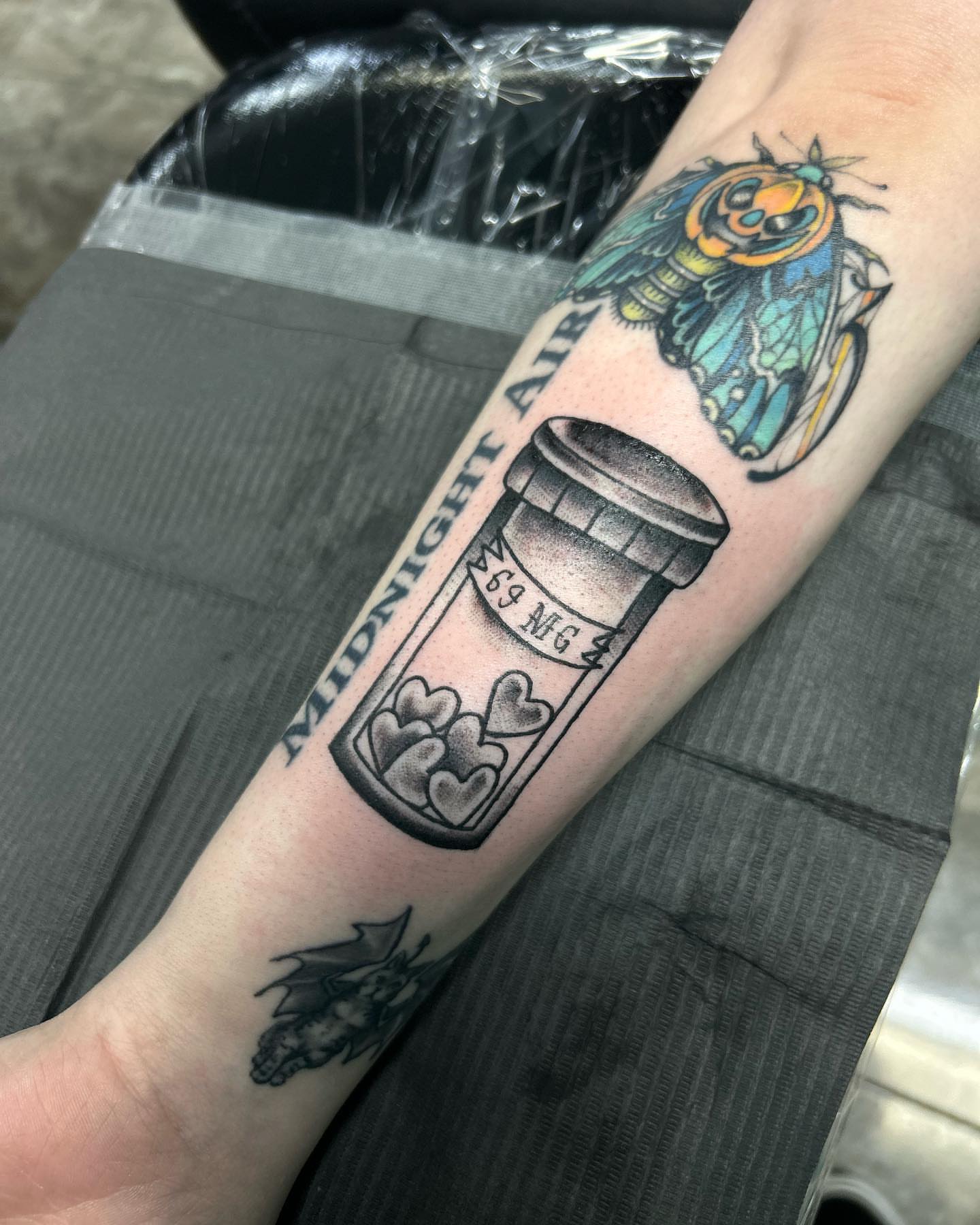 Pill bottle with hearts American traditional tattoo on the forearm by Ares Rhodes