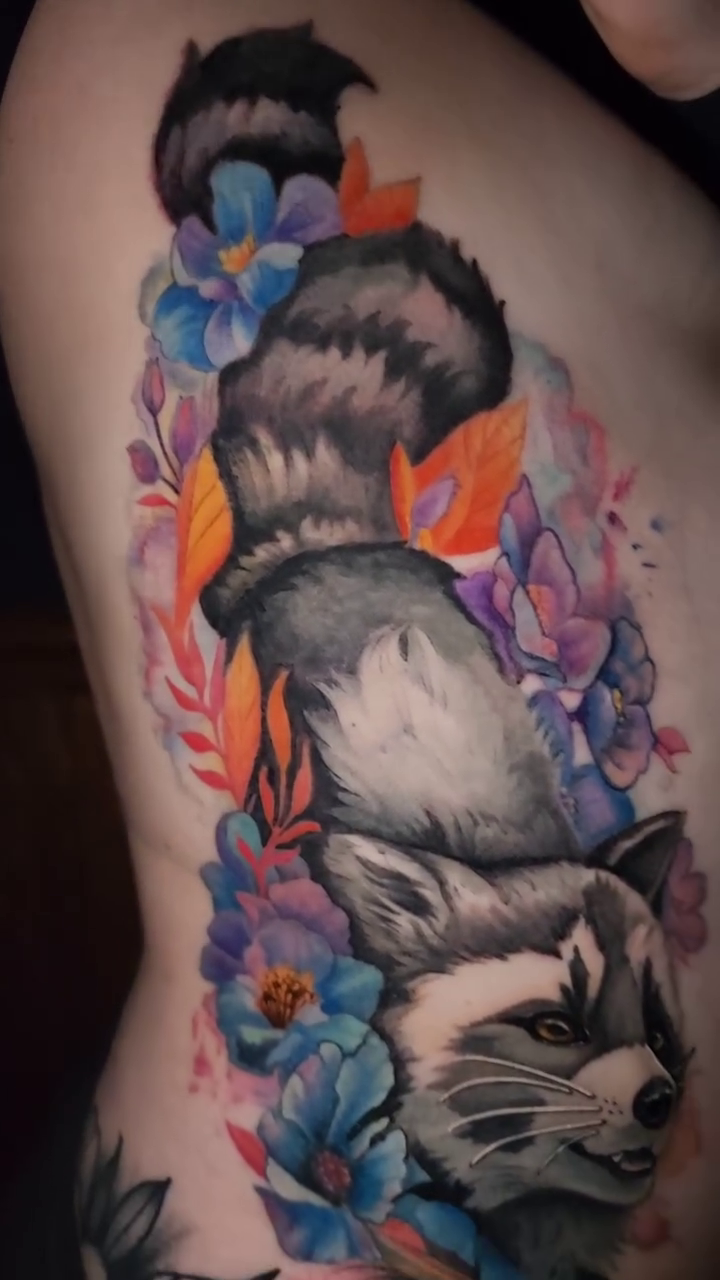 Two raccoons with flowers realism tattoo by Ashlynn Campbell