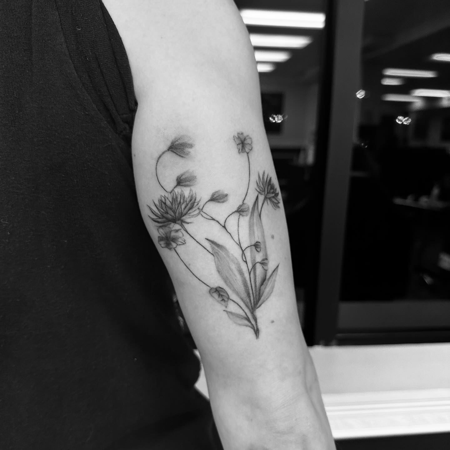Floral arrangement black and grey tattoo on the forearm by chloe🗡️🖤🦇🩸