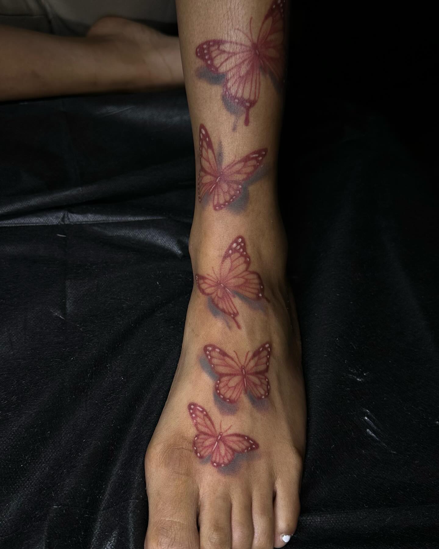 Butterflies realism tattoo on the foot by Jevon Glasco Tattoos