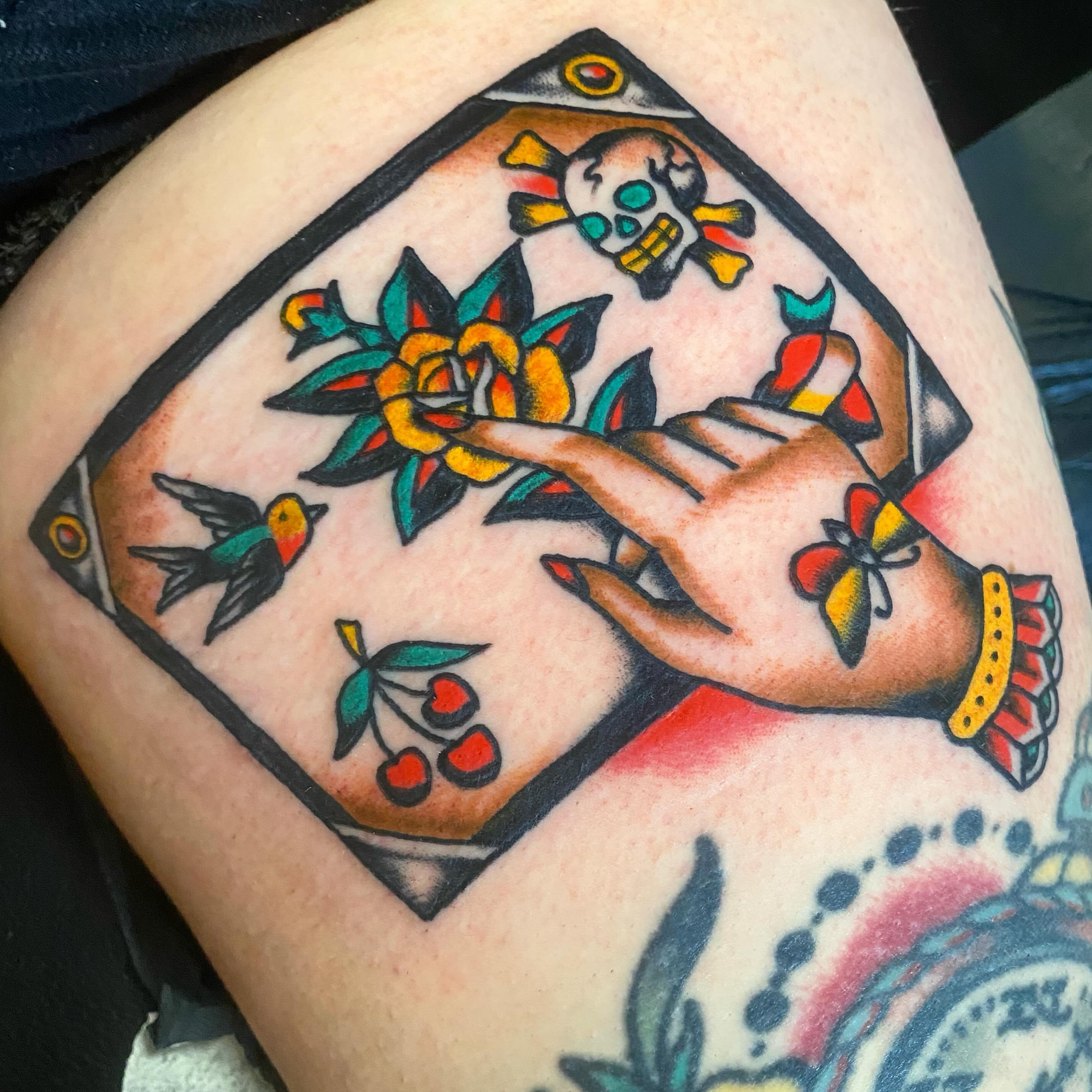 Hand with flower American traditional tattoo on the thigh by Francis Kane
