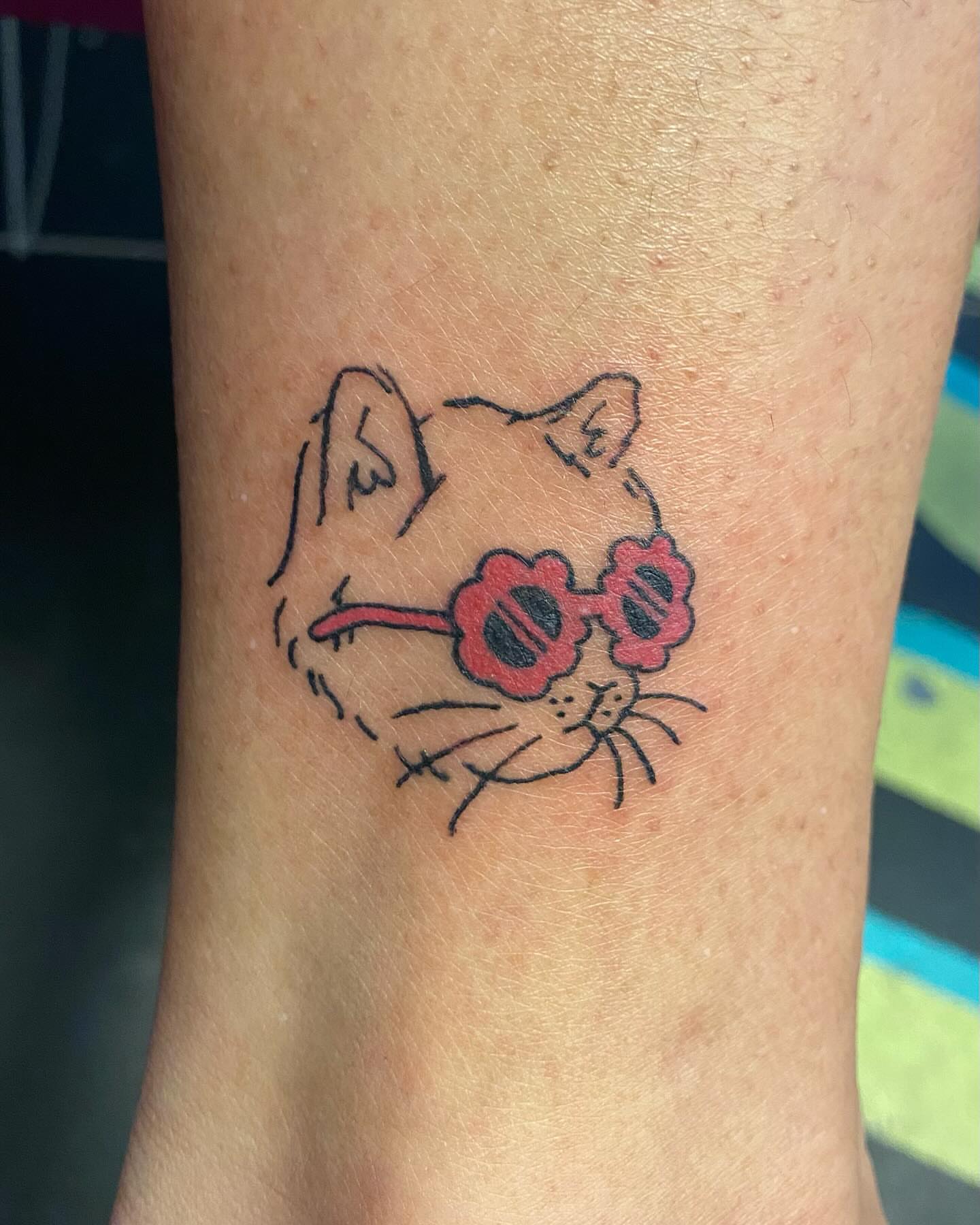 Cat wearing sunglasses fine line tattoo on the forearm by Tesla Kohl