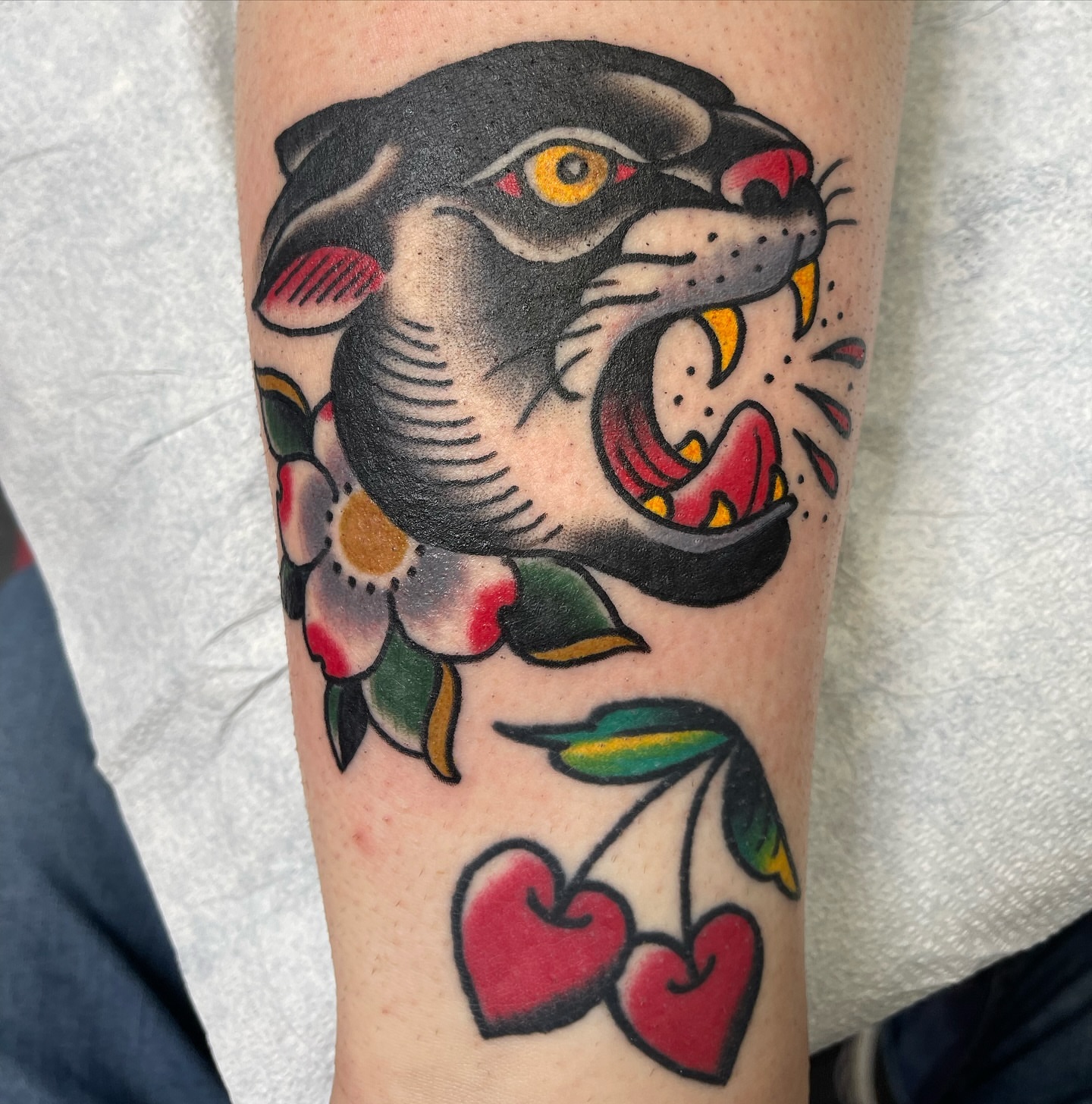 Panther and cherries American traditional tattoo on the forearm by DemianThompson