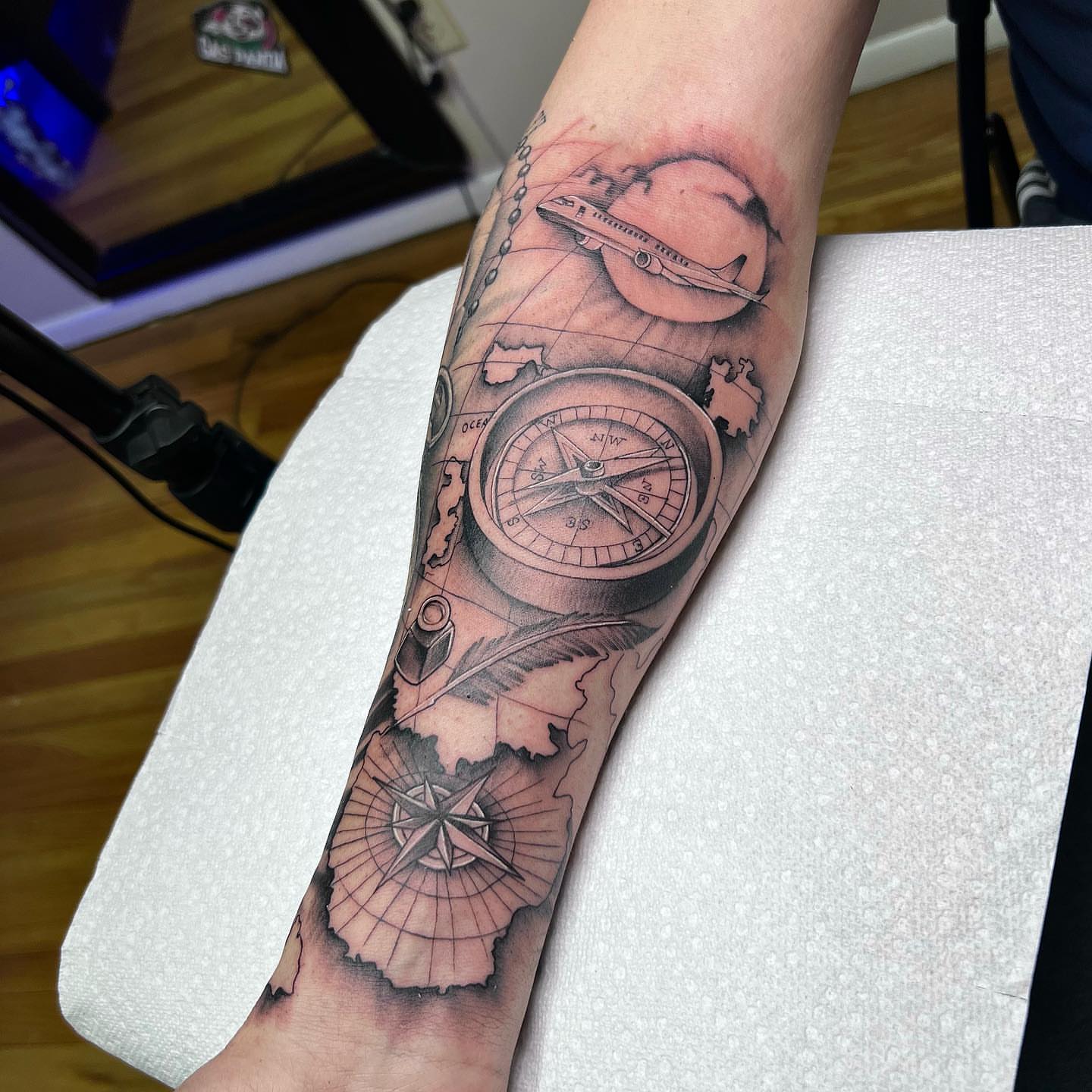 Compass and airplane black and grey tattoo on the forearm by Denis Morello de Castro, South River, New Jersey