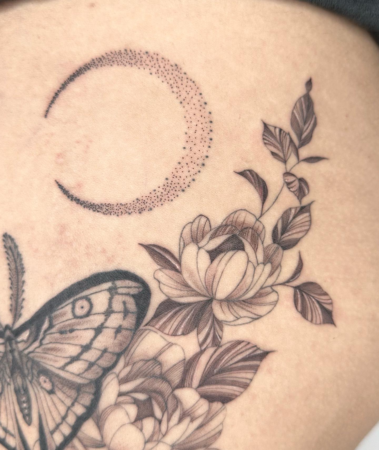 Moon, flowers, butterfly dotwork tattoo on the torso by Sophia Delfino