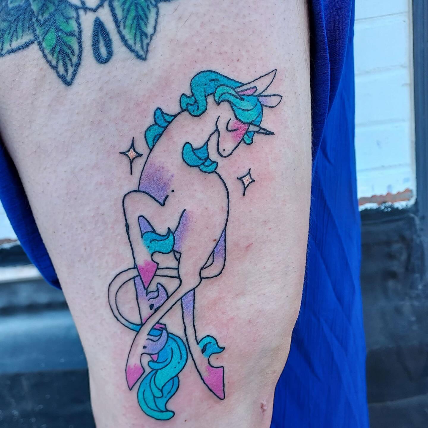 Unicorns watercolor tattoo on the thigh by Spike Cameron
