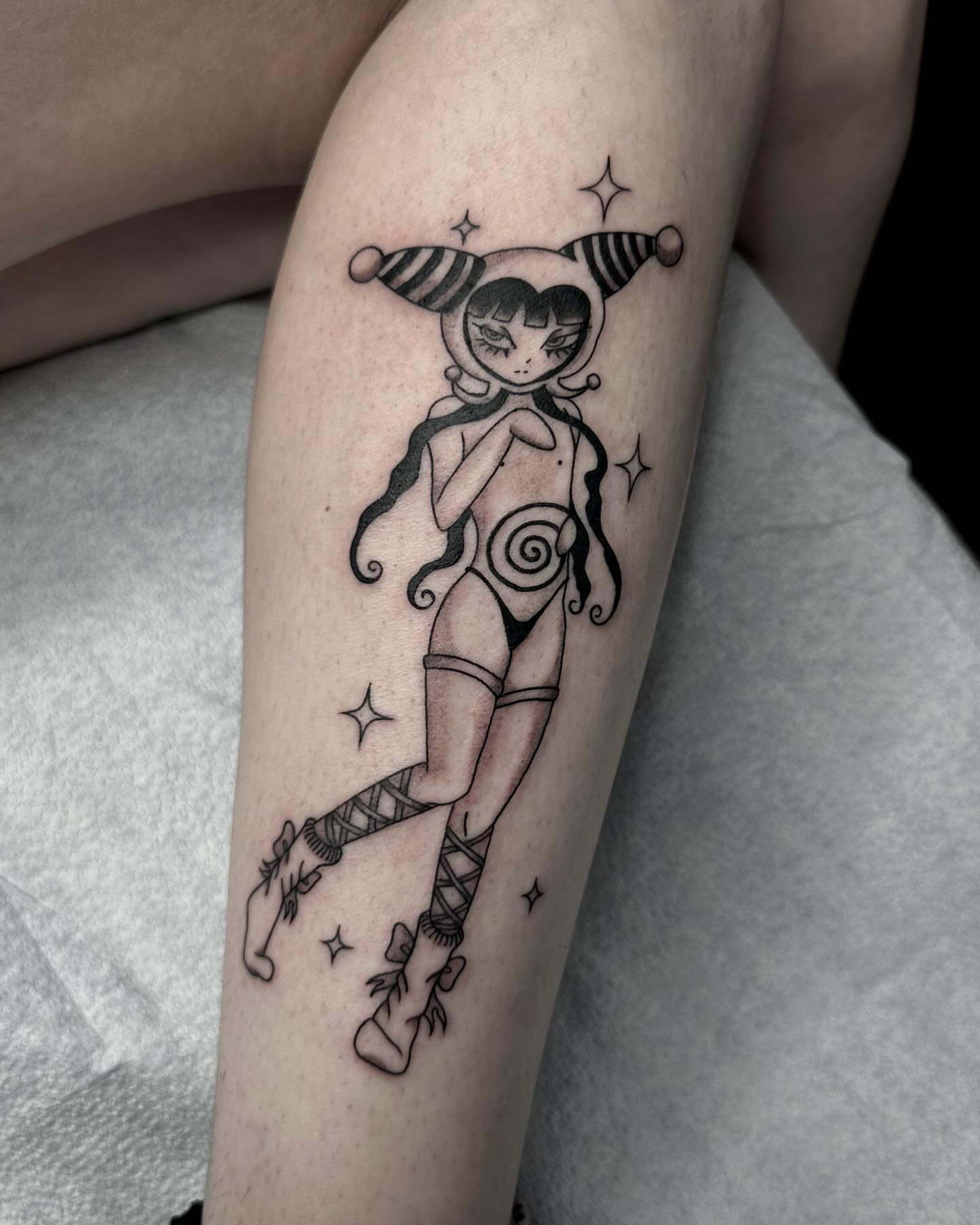Jester girl black and grey tattoo on the forearm by Emersyn DeLuna