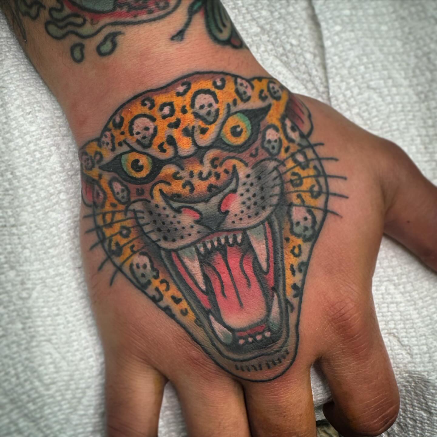 Jaguar American traditional tattoo on the hand by Drew McElveney, Austin, Texas