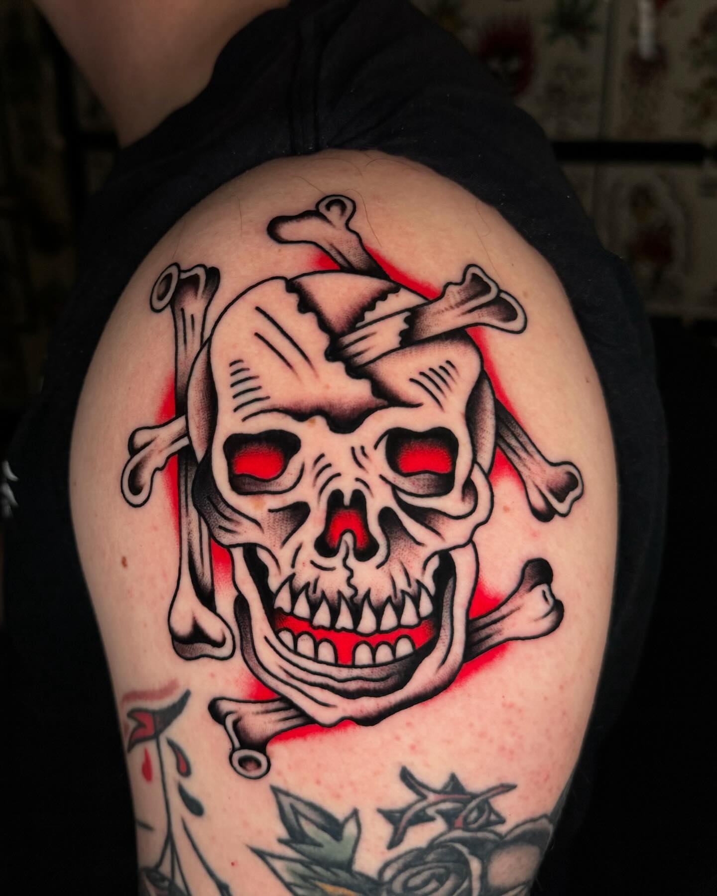 Skull and crossbones American traditional tattoo on the shoulder by James Shepherd, Austin, Texas