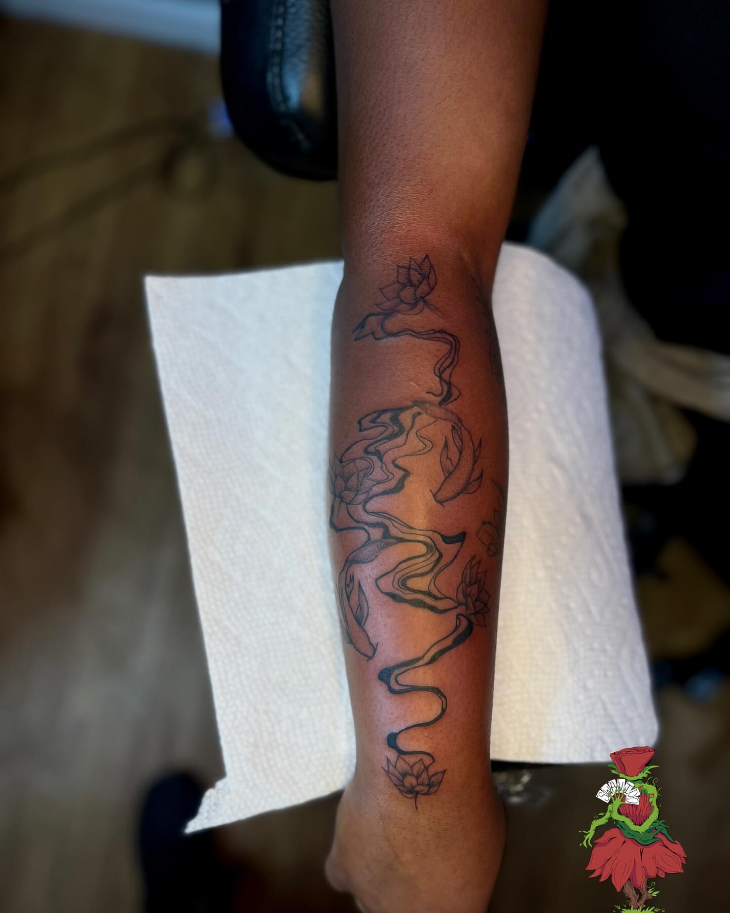 Lotus and smoke black and grey tattoo on the forearm by Marques Neal