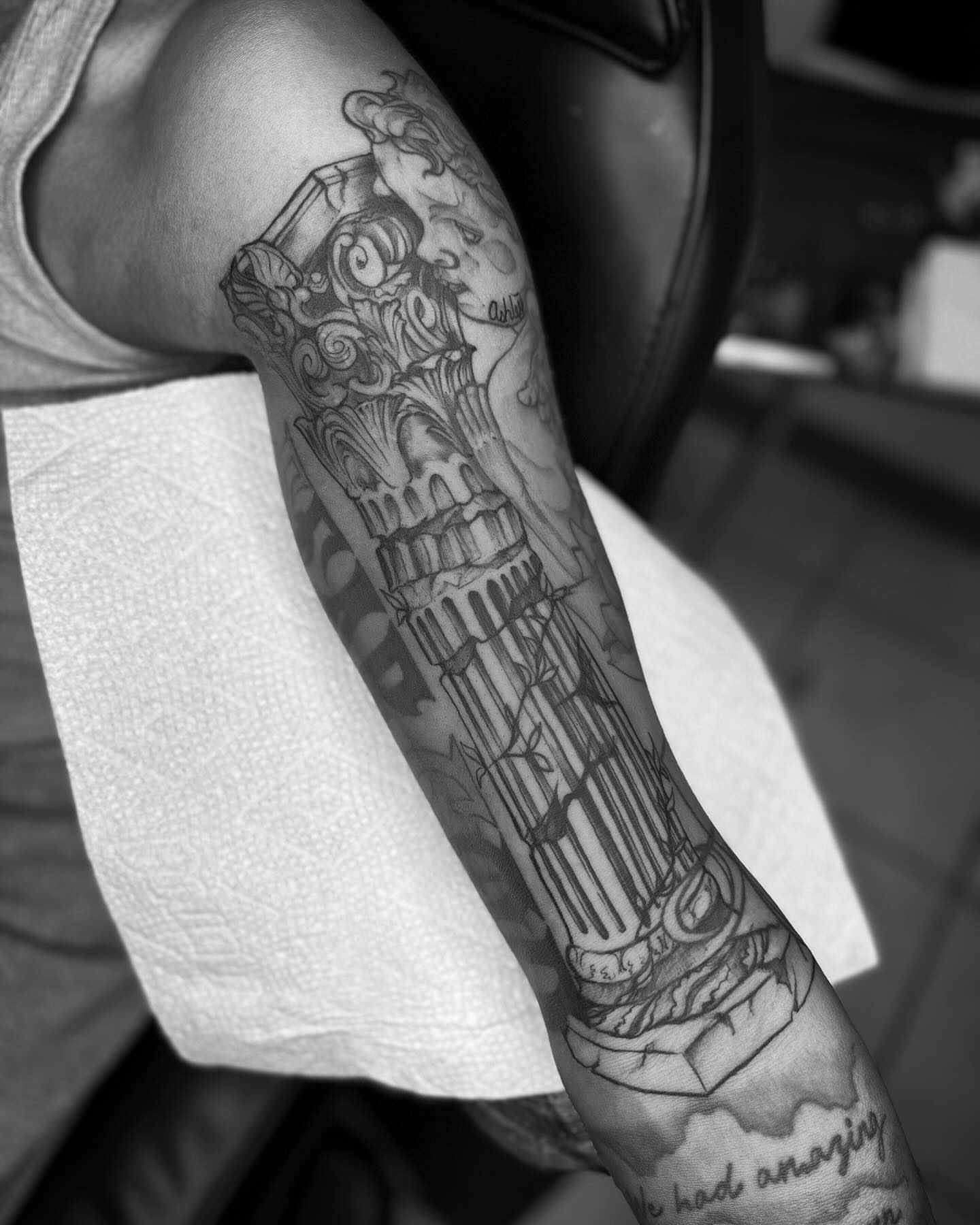 Column and classical figure realism tattoo on the forearm by @inkhazmat