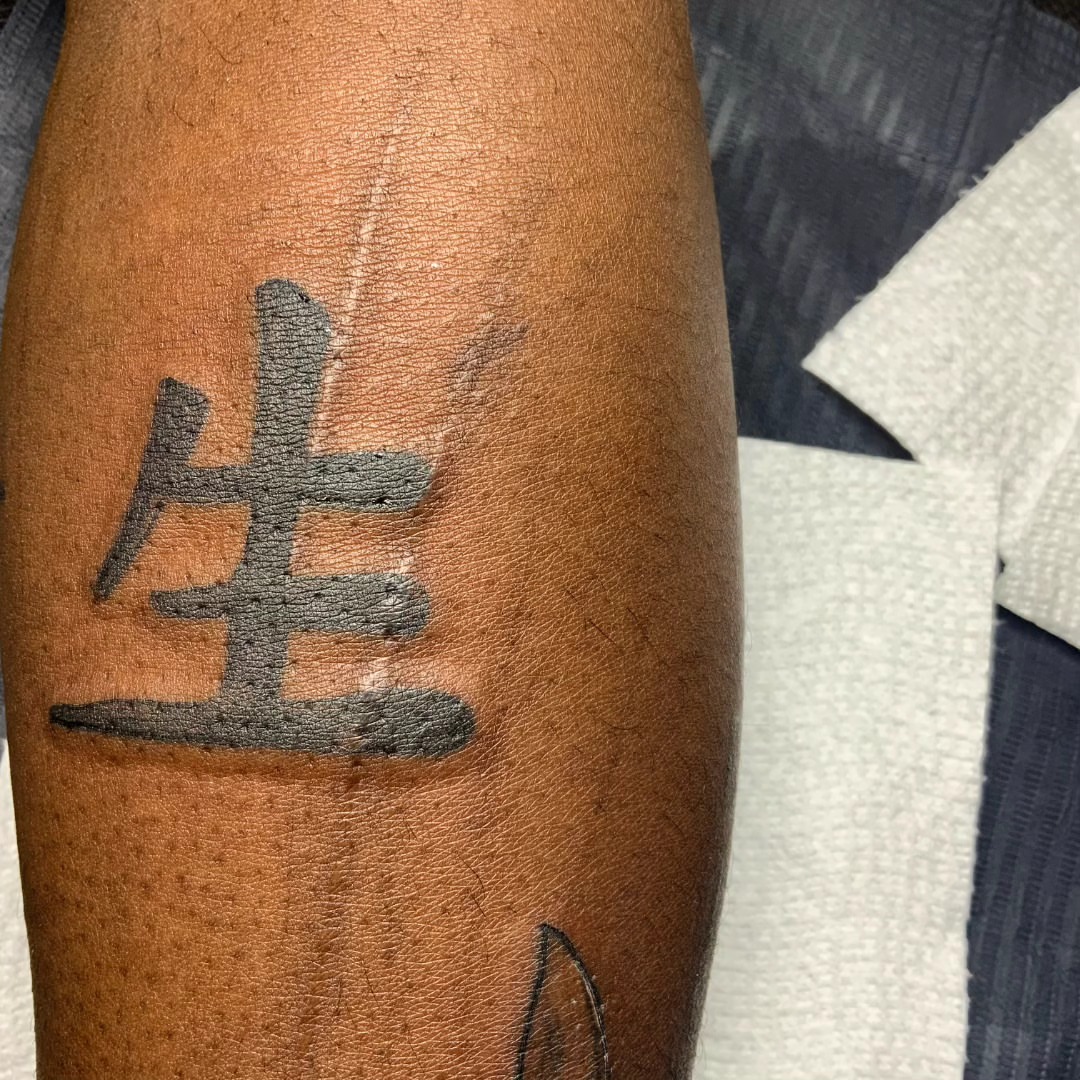 Kanji character black and grey tattoo on the forearm by Lopez Dautruche