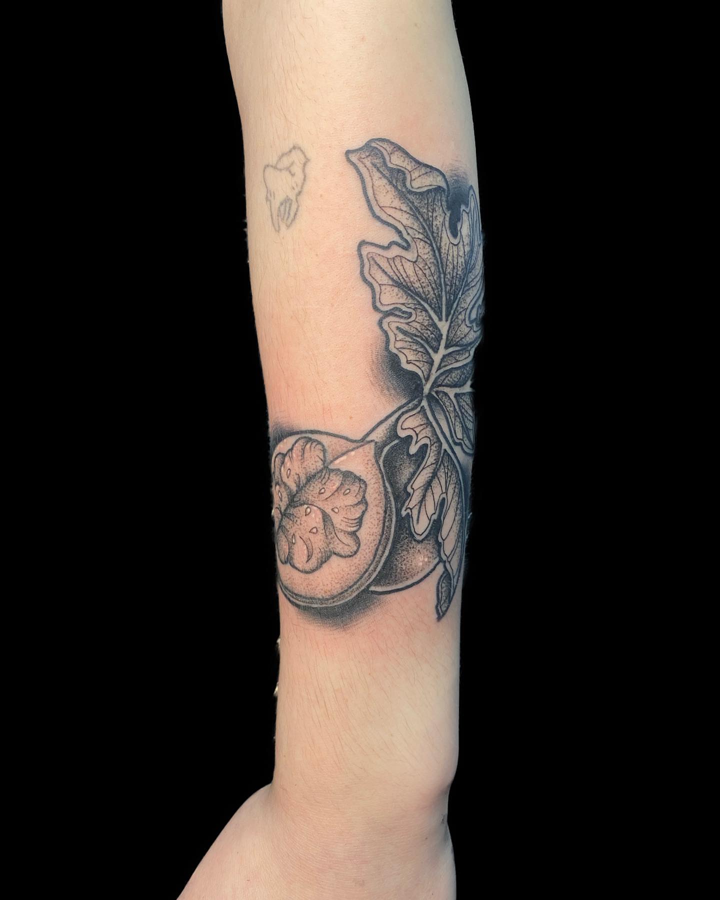Watermelon slice black and grey tattoo on the forearm by Shelby Warren