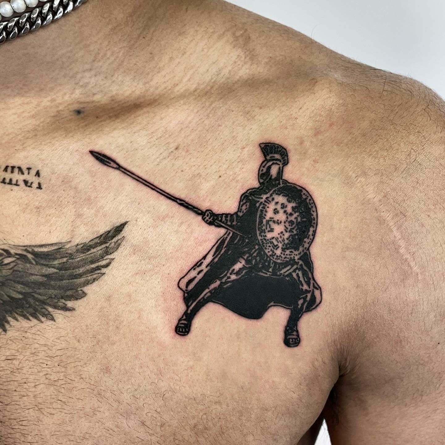 Ancient warrior black and grey tattoo on the chest by utility pole