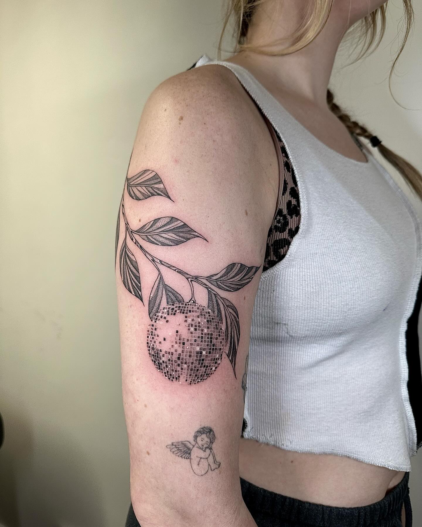 Fruit and leaves dotwork tattoo on the upper arm by Fine line tattoo San Diego, San Diego, California