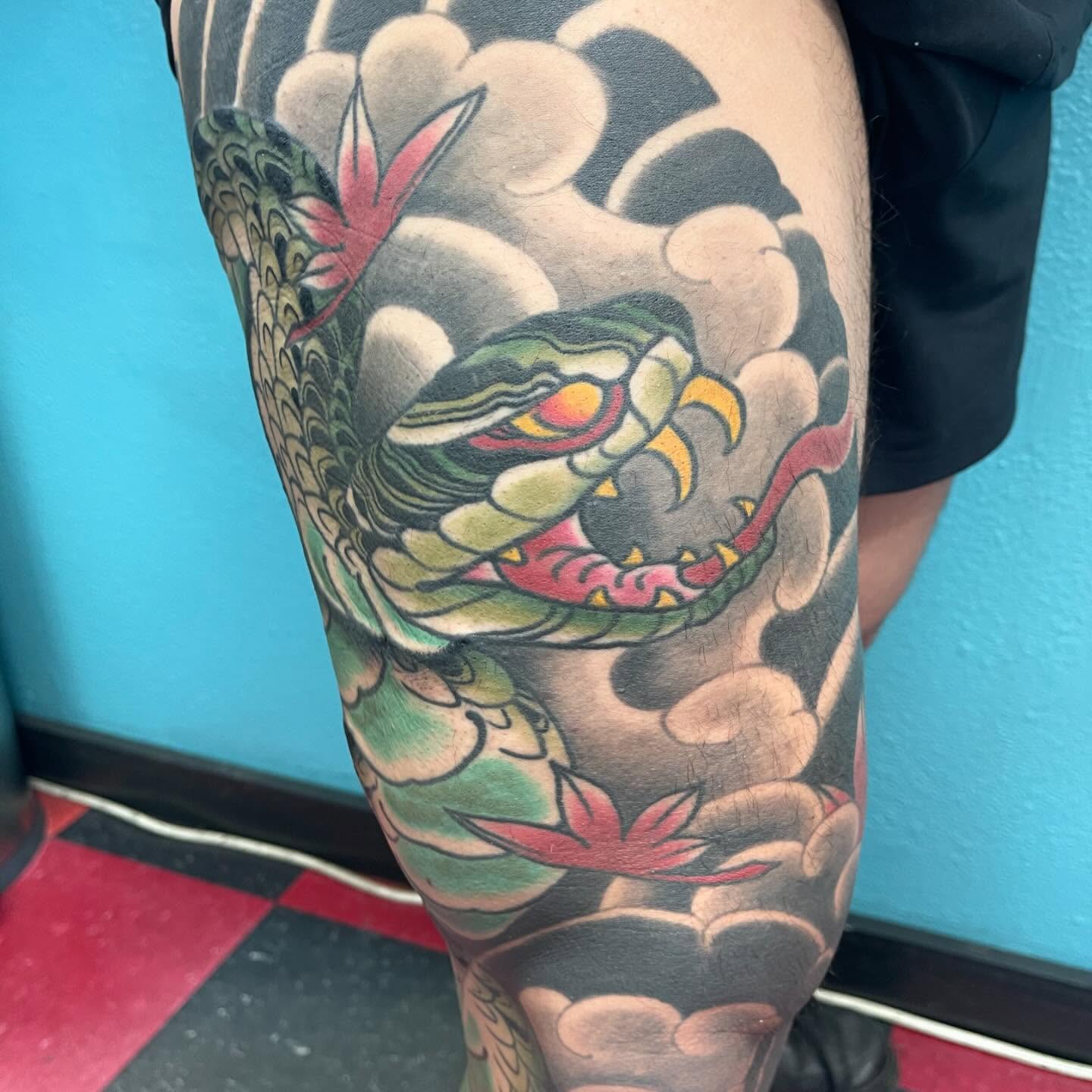 Snake and clouds American traditional tattoo on the thigh by DemianThompson
