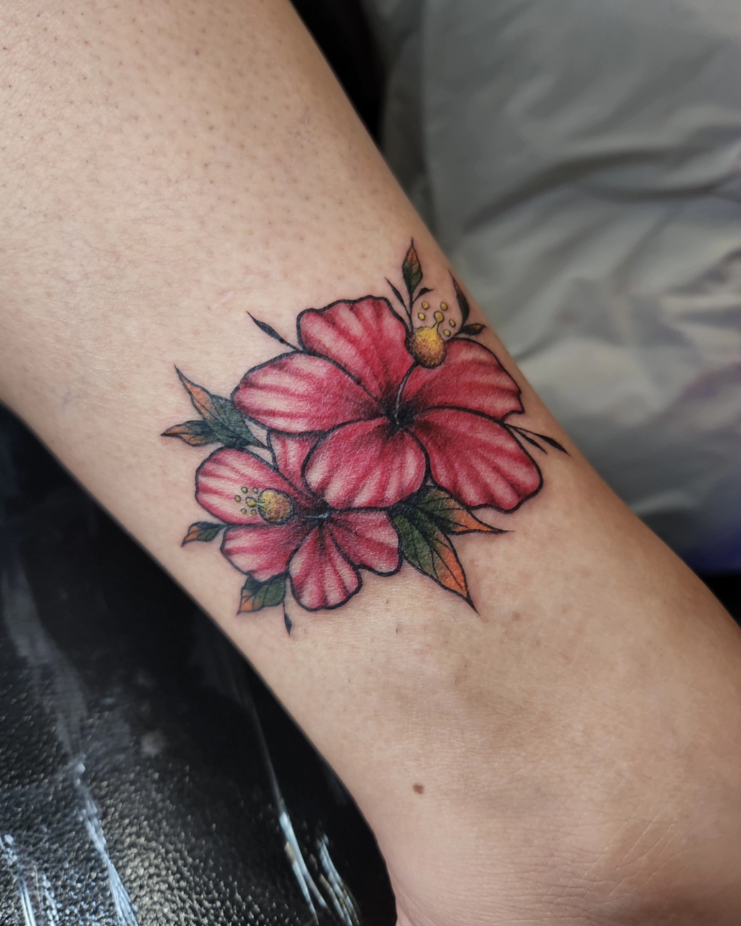 Hibiscus flowers realism tattoo on the forearm by Adrian Chavez