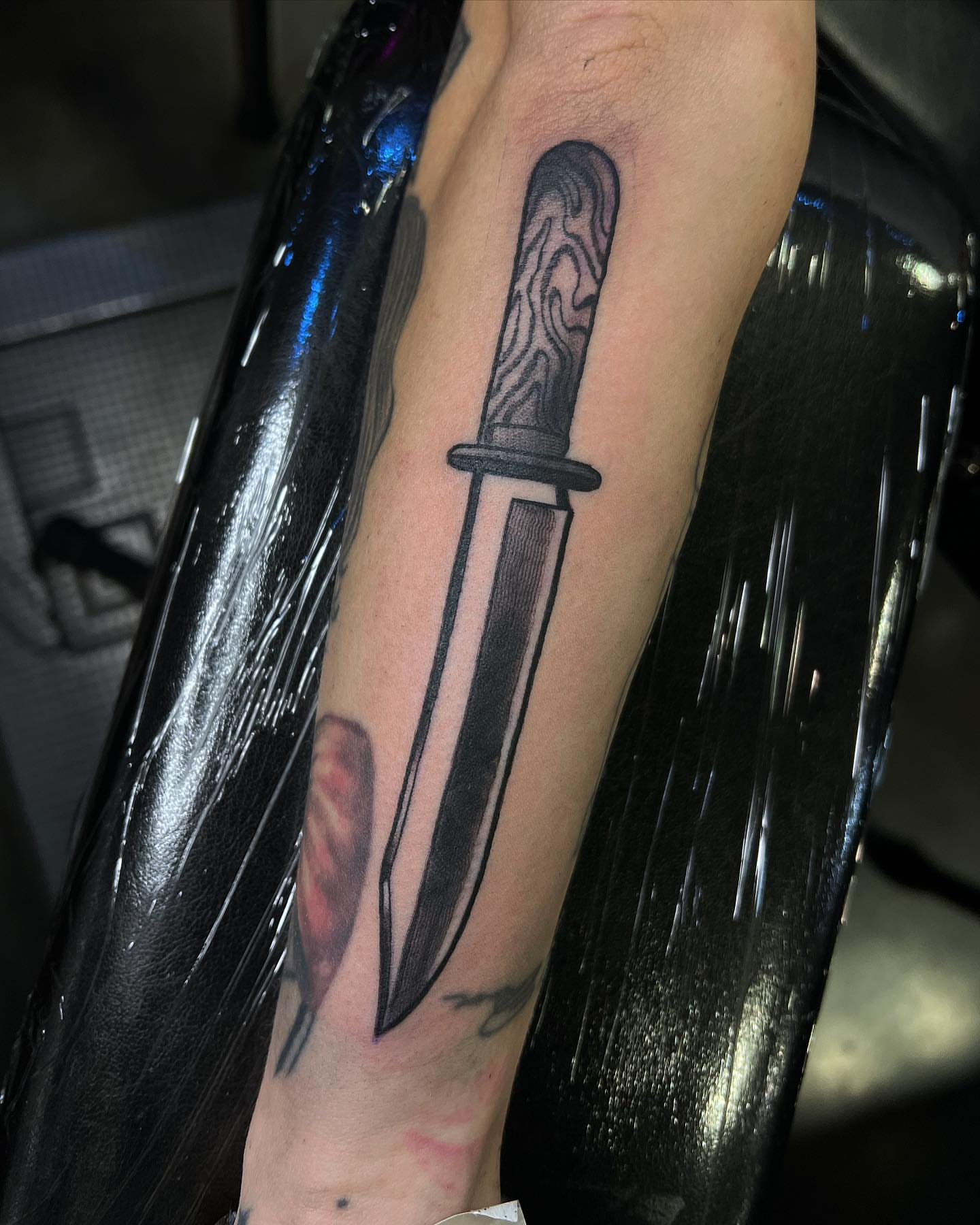 Knife black and grey tattoo on the forearm by Daniel Patrick