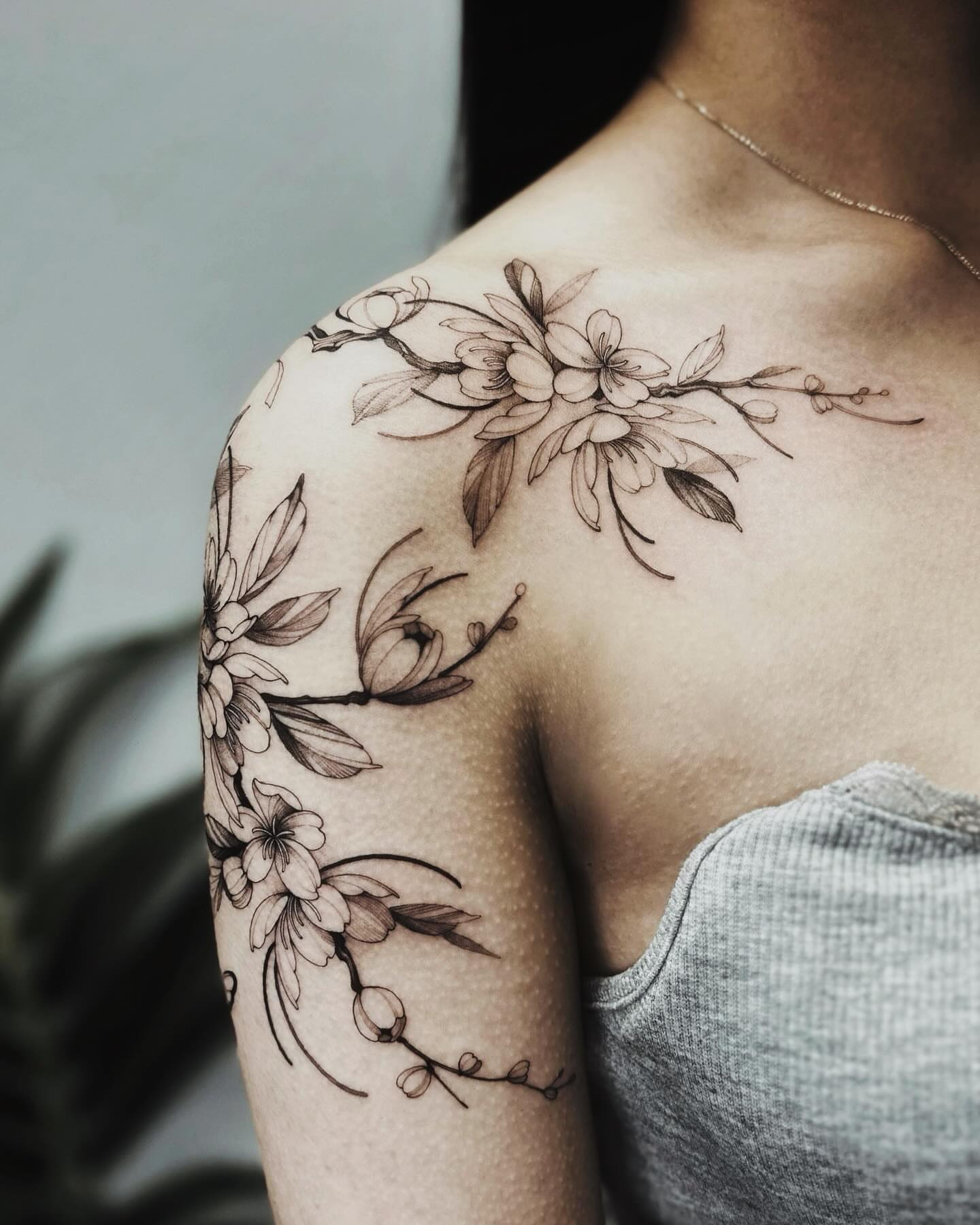 Floral arrangement black and grey tattoo on the shoulder by Angel