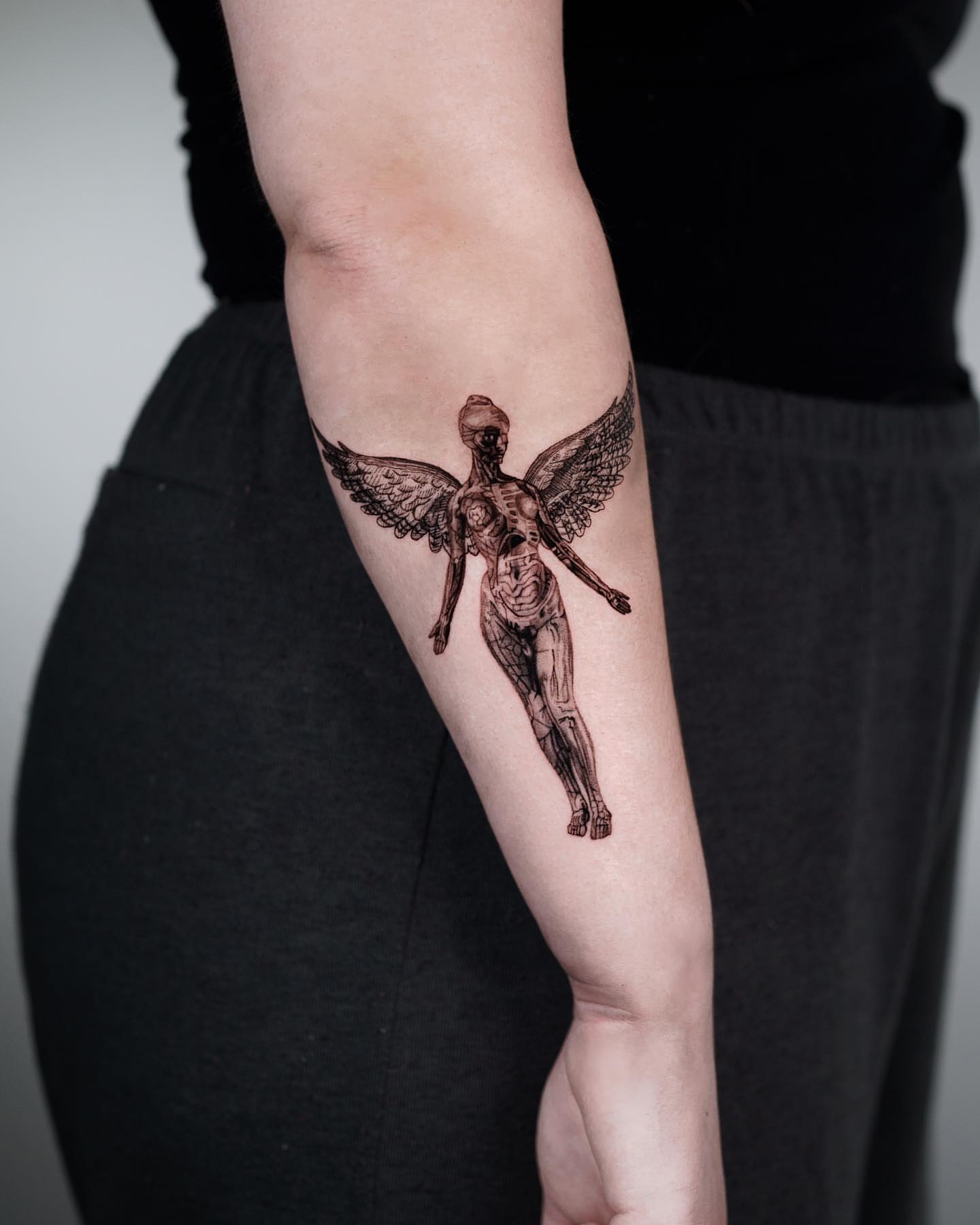 Winged anatomical figure black and grey tattoo on the forearm by Anthony “Jiinky” Quintanilla 🧸☁️