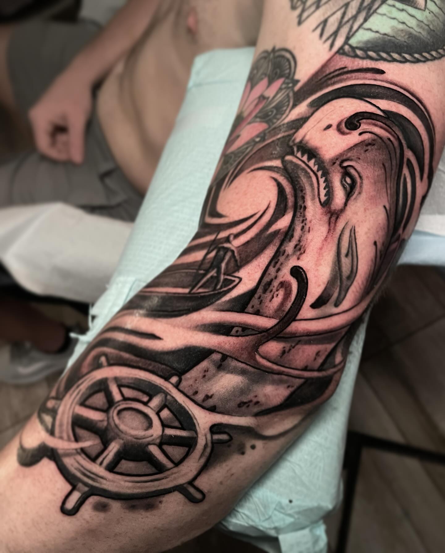 Ship wheel and waves realism tattoo on the forearm by Alex Rockoff